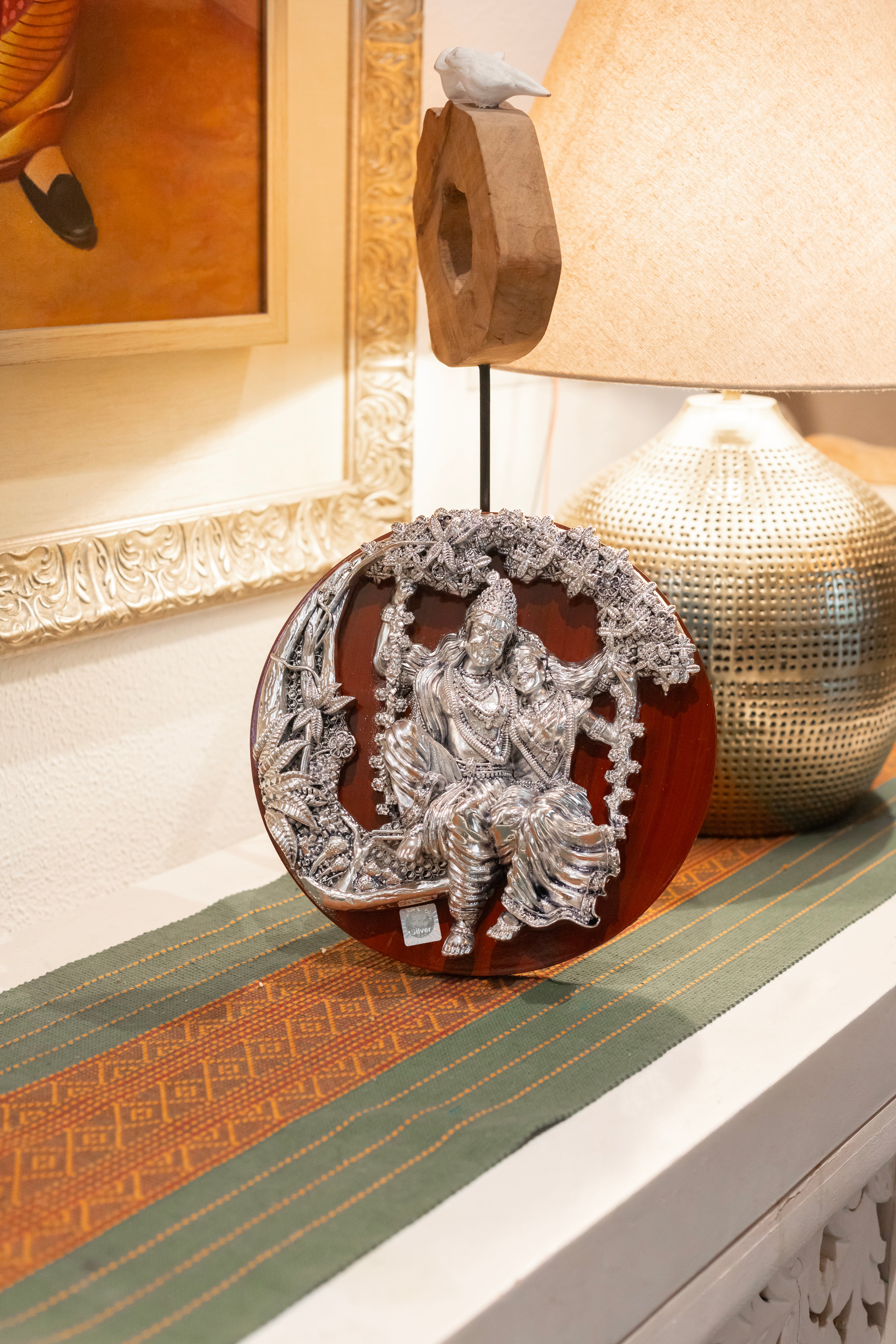 Pure silver Radha Krishna sculpture on wooden frame by Rasava Jewels, detailed handcrafted Indian religious art.