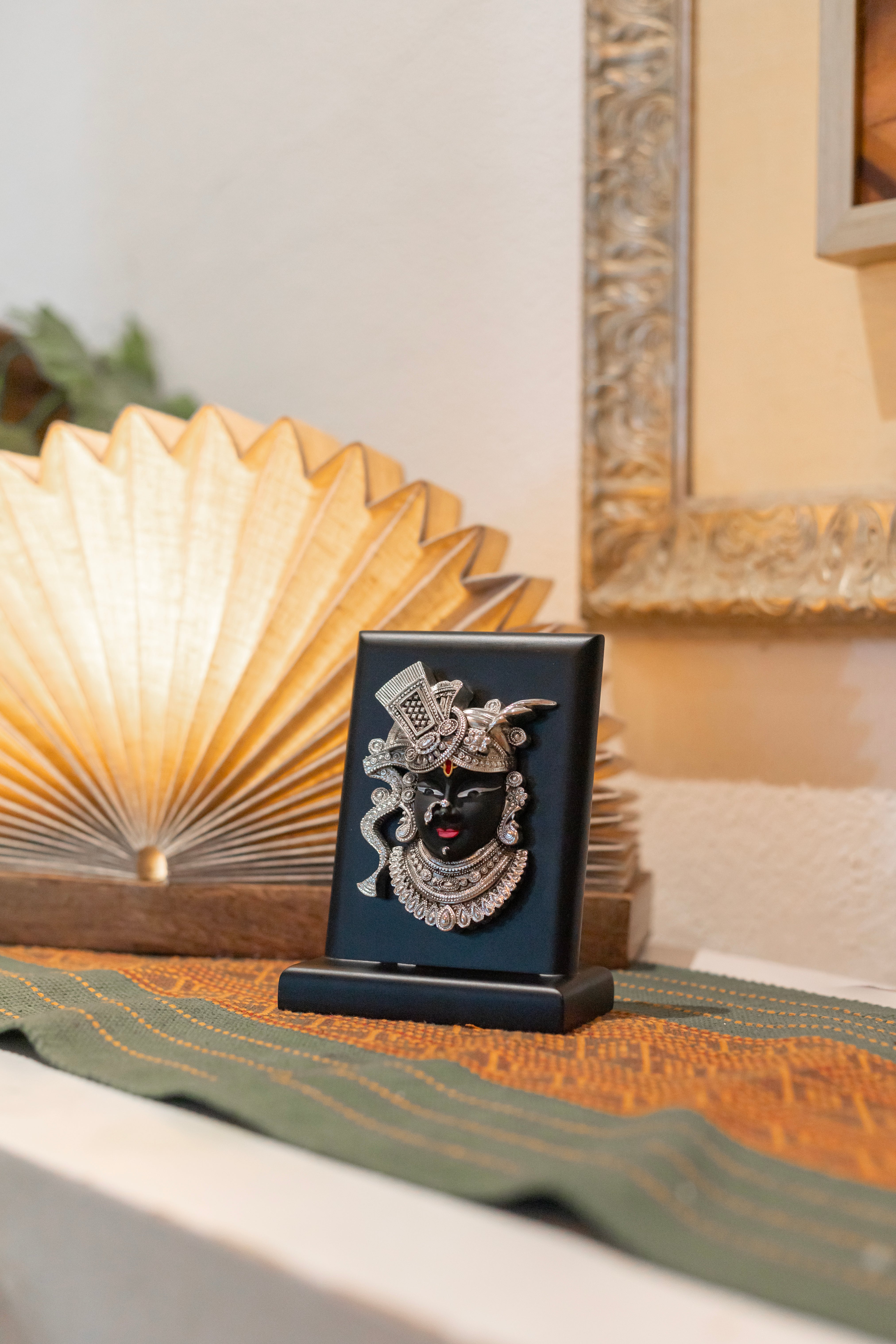 Pure silver Shrinath Ji idol on black base, detailed craftsmanship by Rasava Jewels, ideal for spiritual decor.