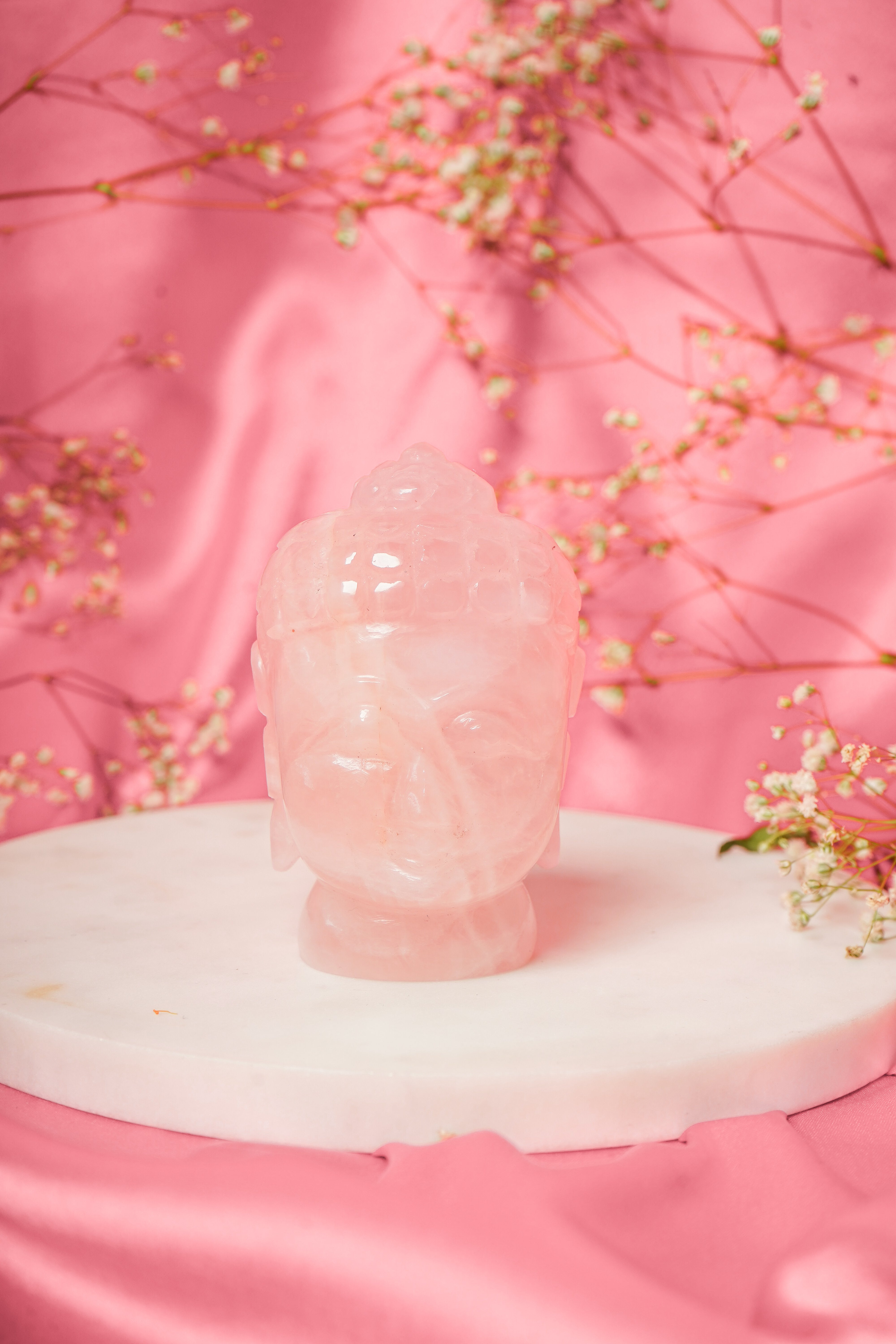 Natural rose quartz Buddha head sculpture with detailed facial features and smooth polished surface, ideal for meditation and decor.