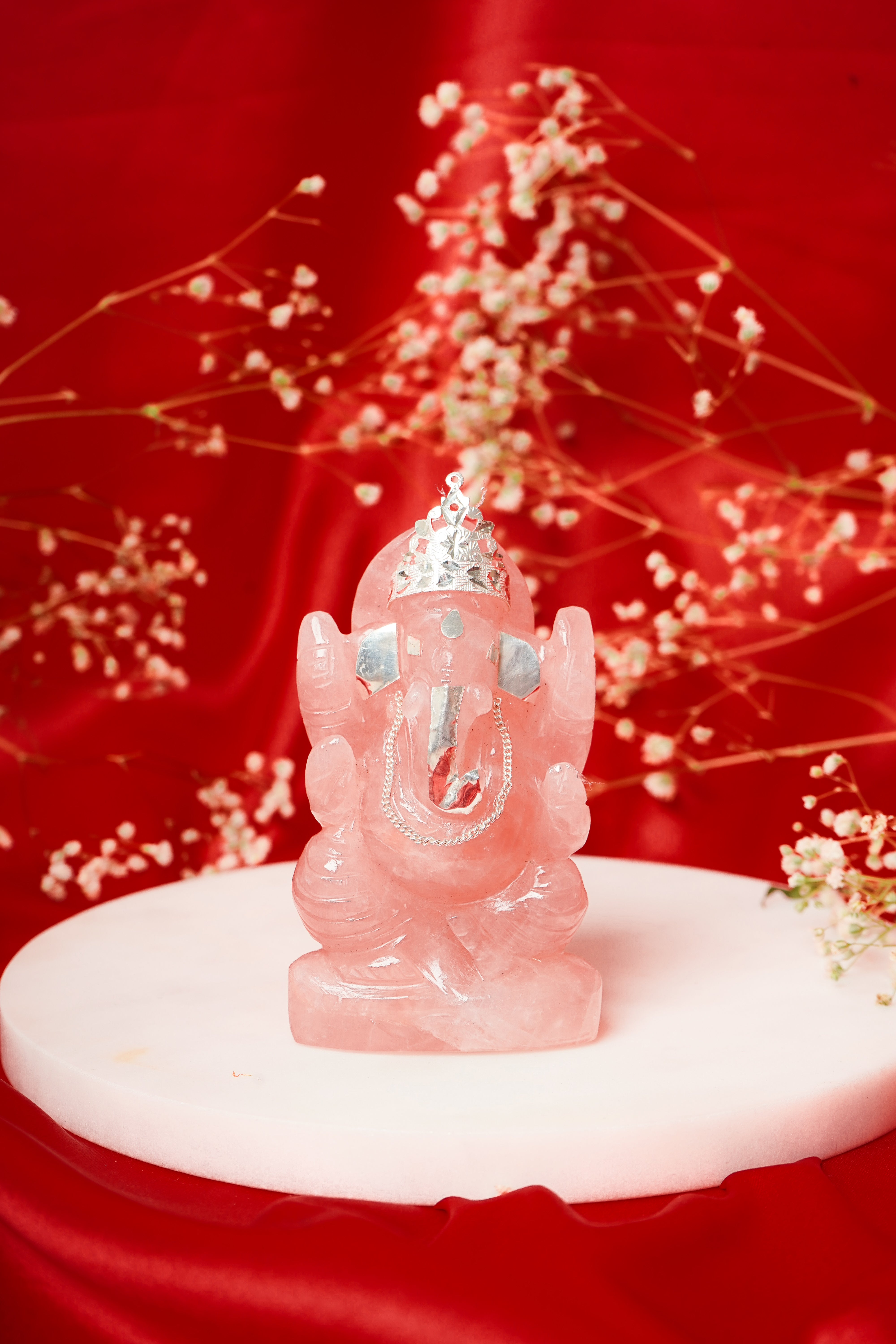 Natural rose quartz Ganesh ji statue with silver accents, featuring intricate carvings and a smooth polished finish.