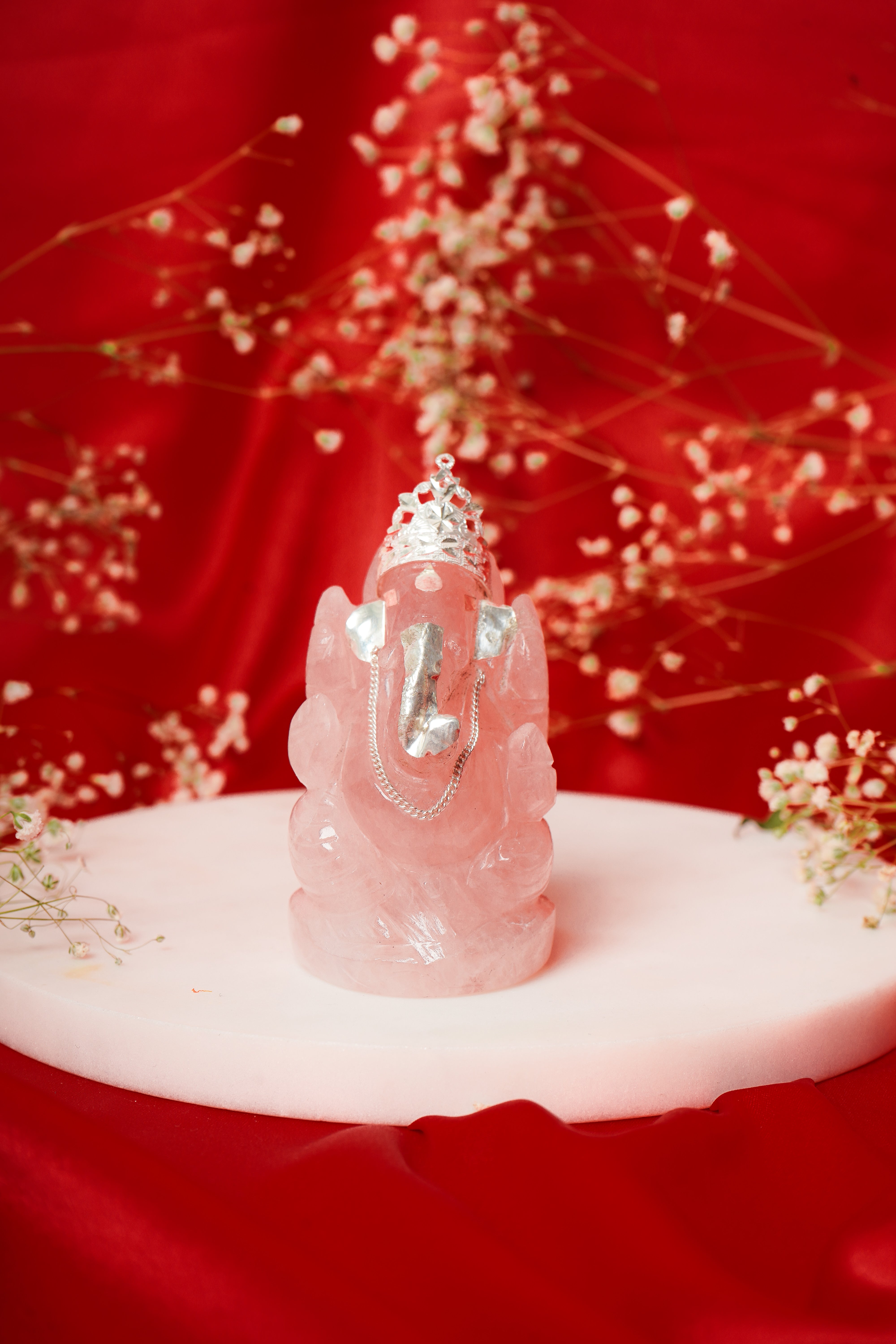 Natural rose quartz Ganesh ji figurine with silver accents, showcasing a detailed carved Hindu deity sculpture.