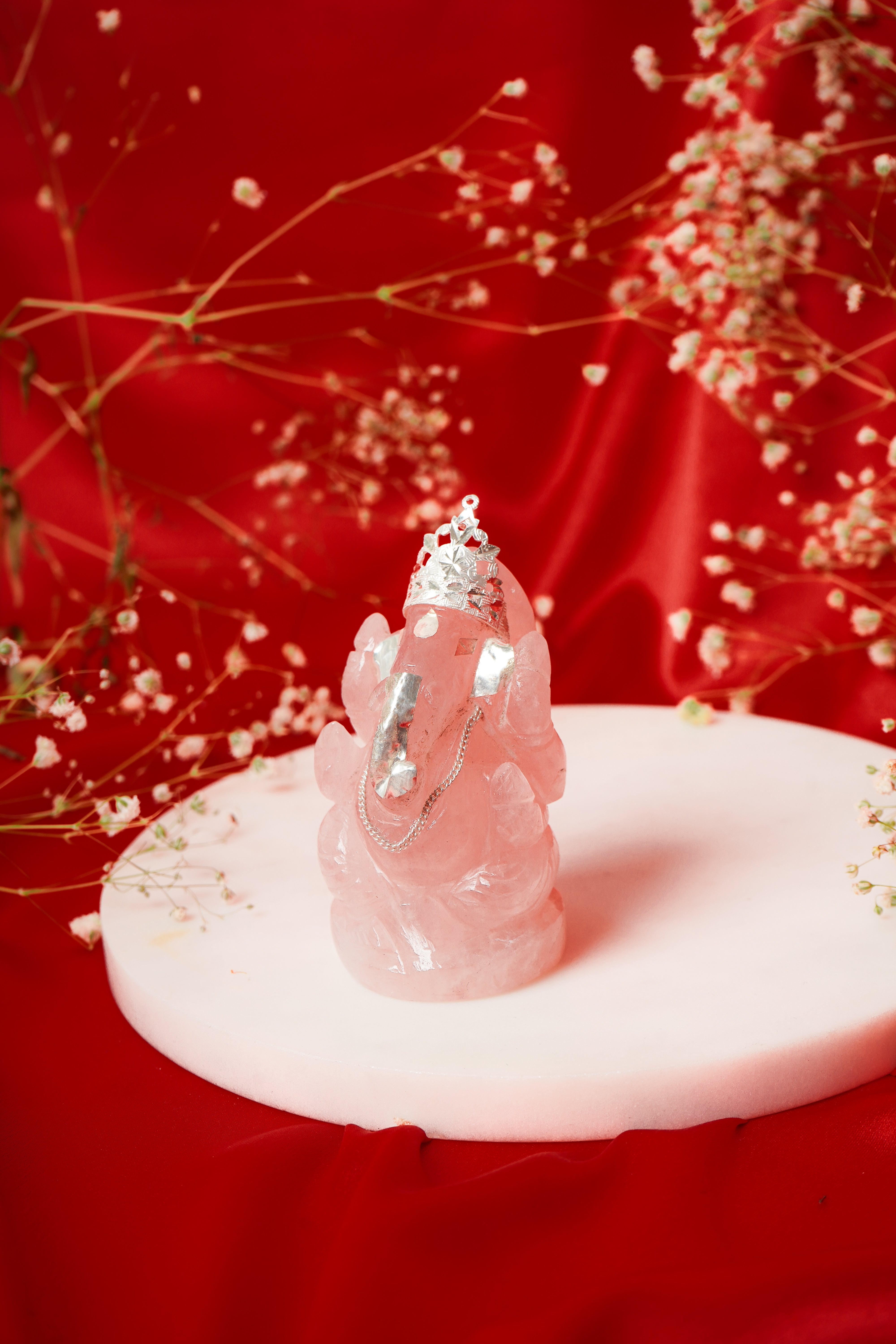 Natural rose quartz Ganesh ji sculpture with silver accents, showcasing intricate craftsmanship and vibrant pink hues.