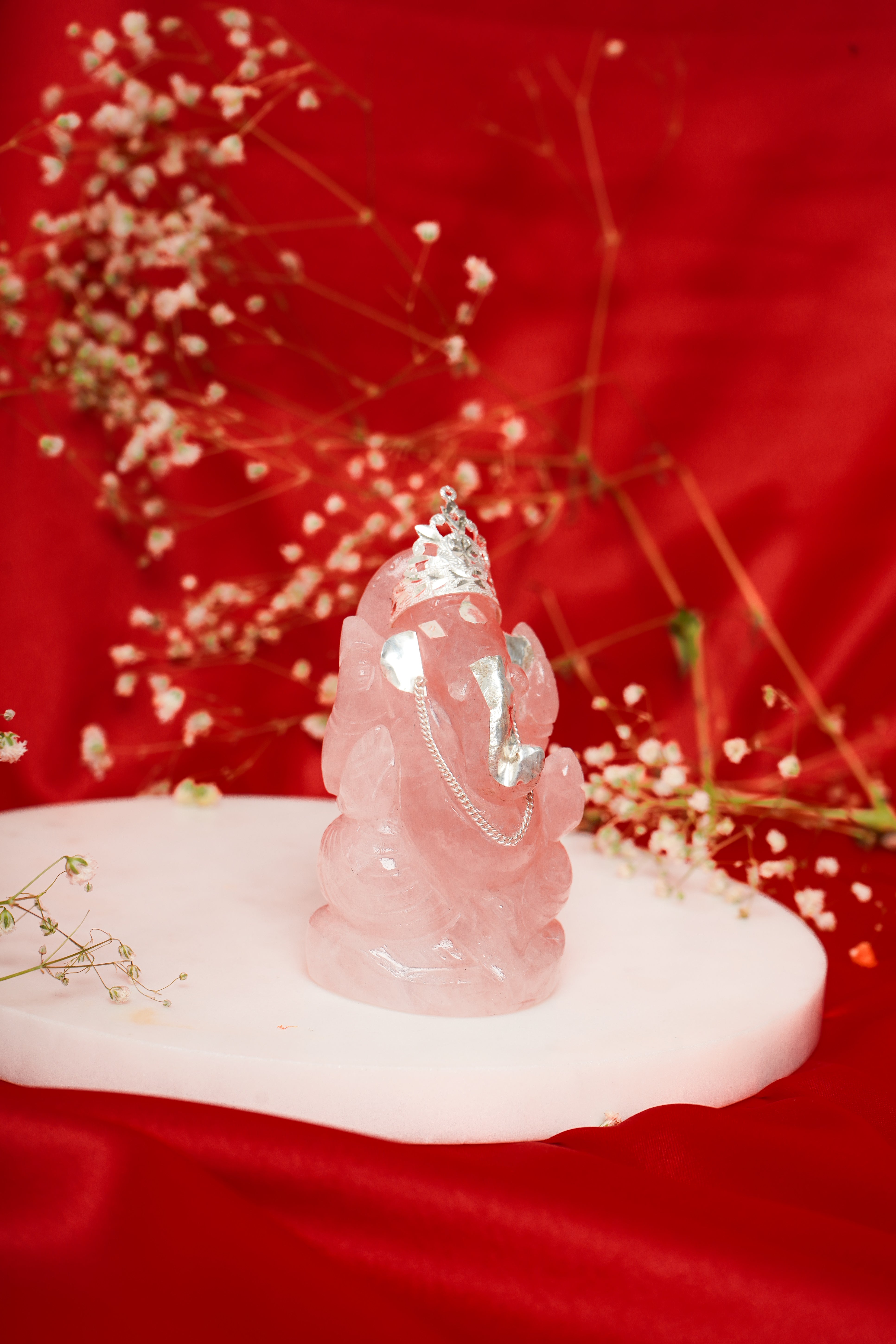 Natural rose quartz Ganesh ji figurine with silver accents, showcasing intricate craftsmanship and vibrant pink hues.
