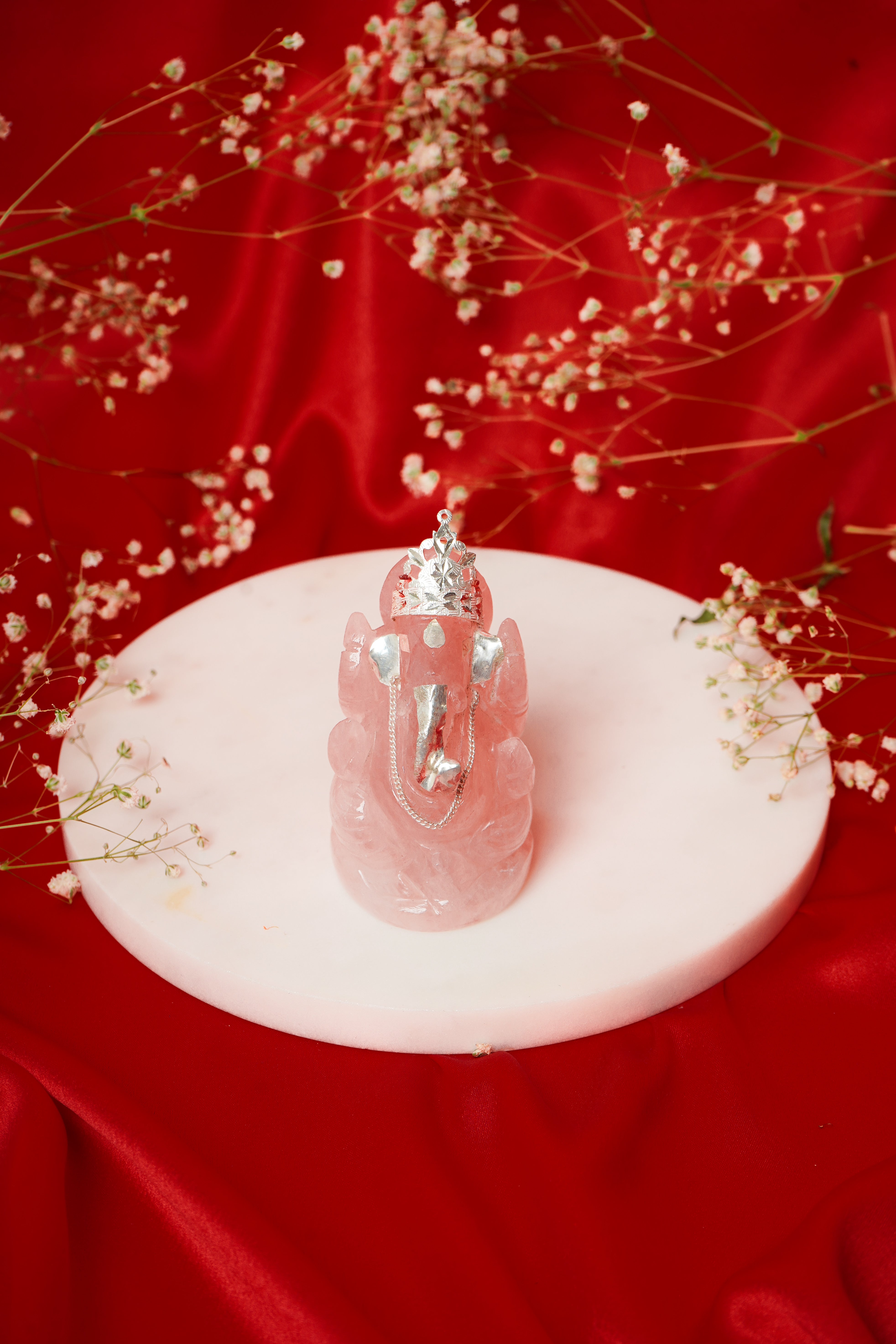 Natural rose quartz Ganesh Ji statue with silver accents, showcasing intricate craftsmanship and vibrant pink gemstone details.