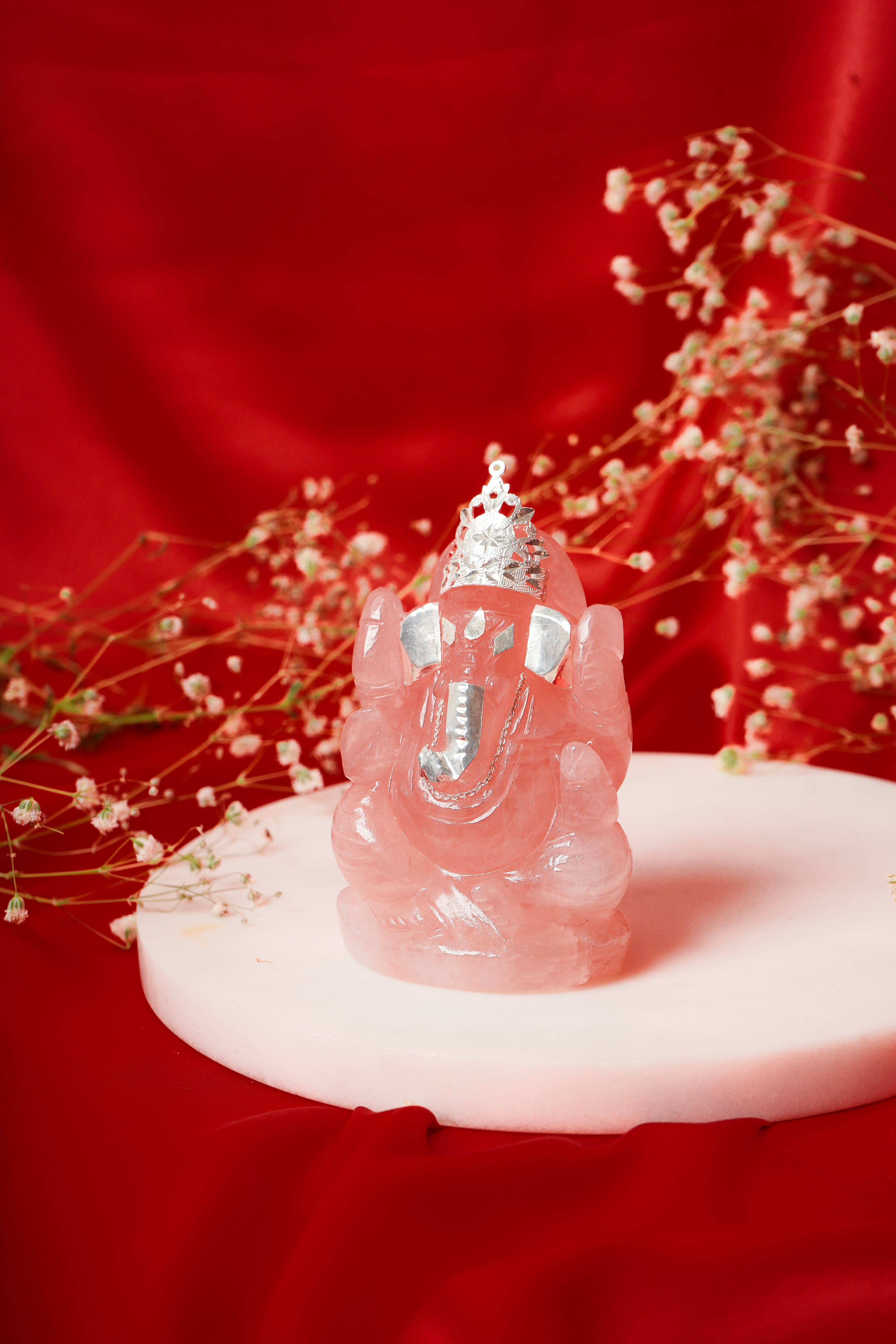 Natural rose quartz Ganesh ji statue with silver accents, depicting Lord Ganesha in a detailed, polished stone sculpture.