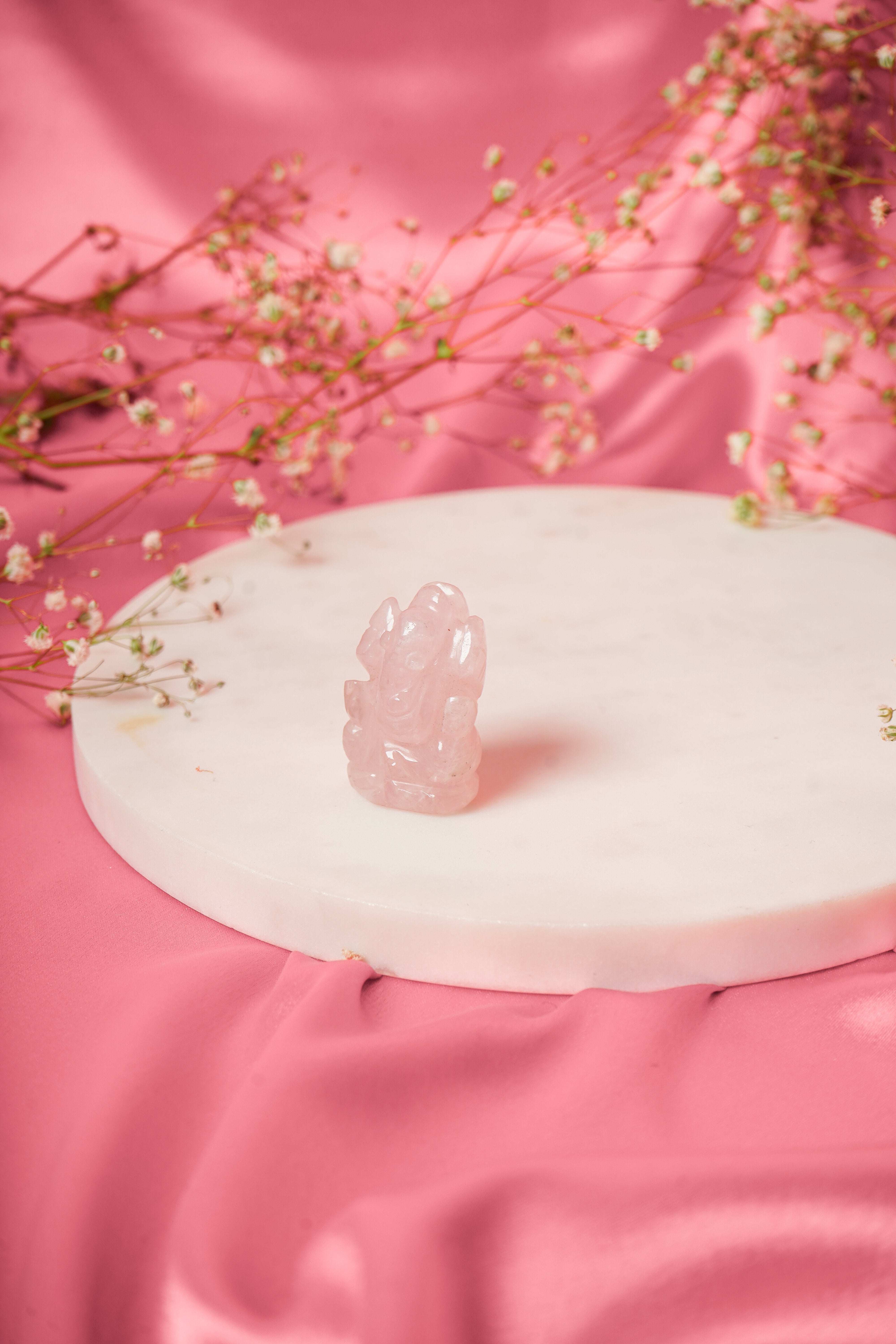 Natural rose quartz Ganesh ji figurine with intricate carvings, showcasing a serene Hindu deity in soft pink gemstone.