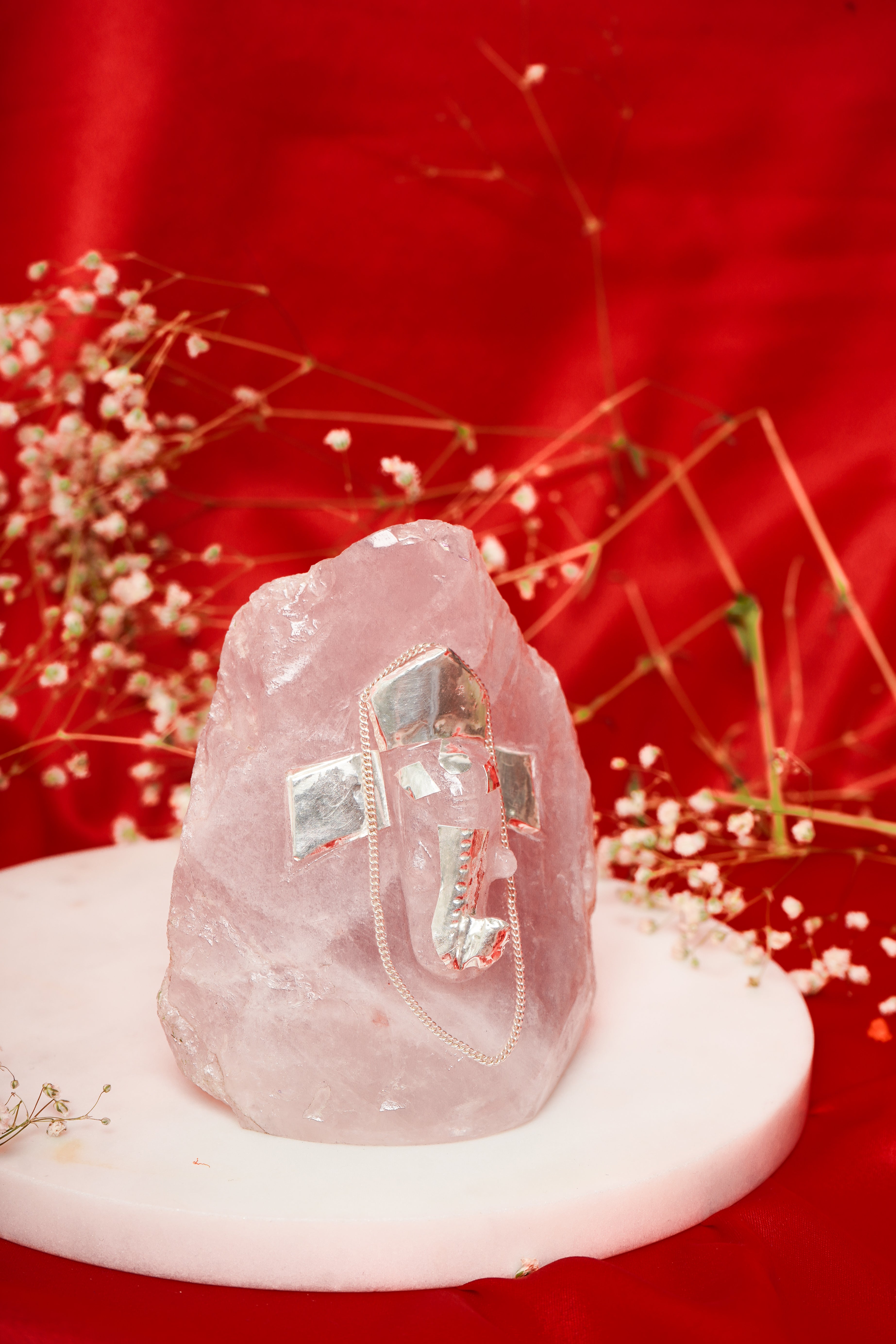 Natural rose quartz Ganesh ji sculpture with silver accents, unshaped, crafted for spiritual and decorative purposes.