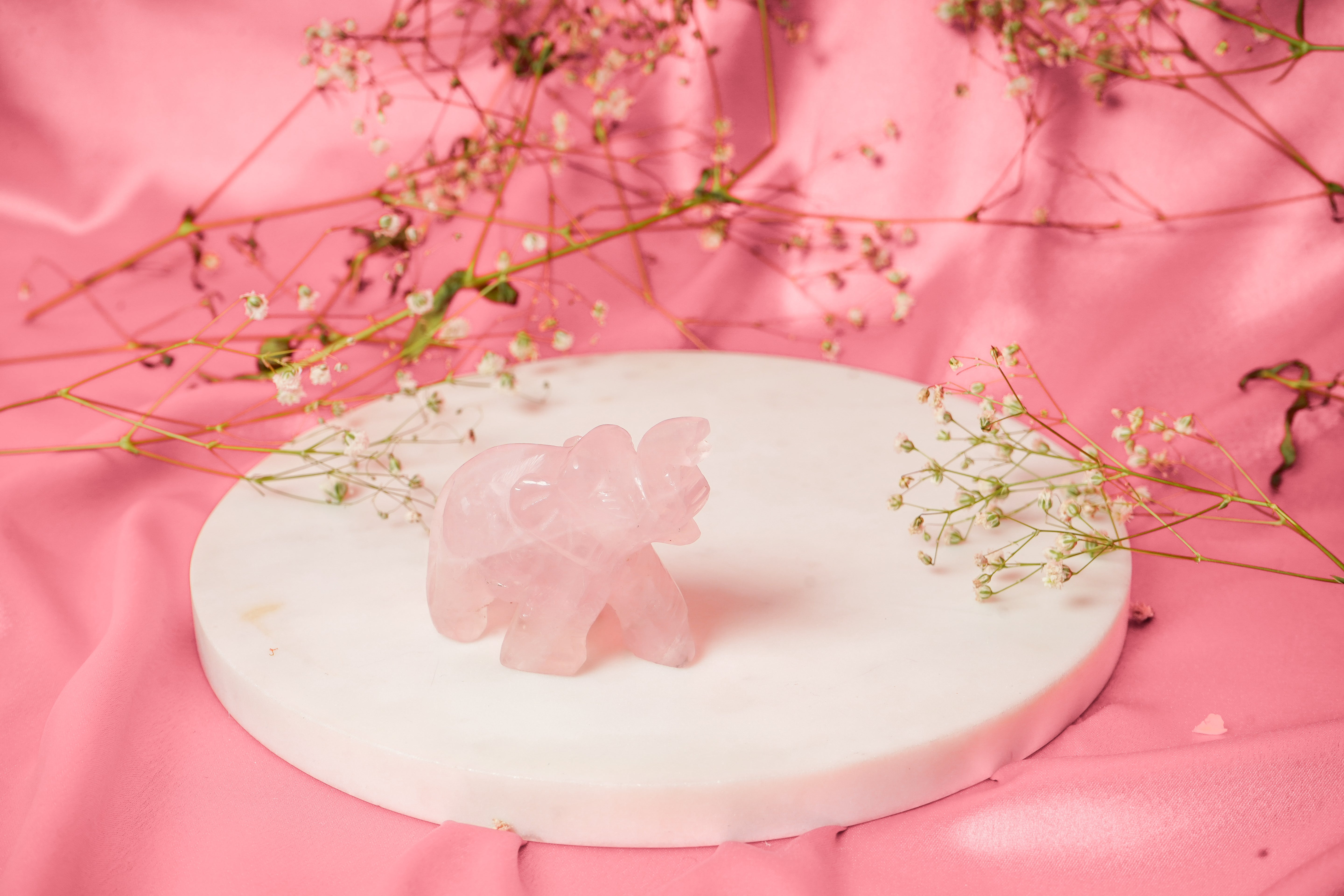 Natural rose quartz elephant figurine with smooth pink stone and carved details, showcasing a decorative gemstone animal.