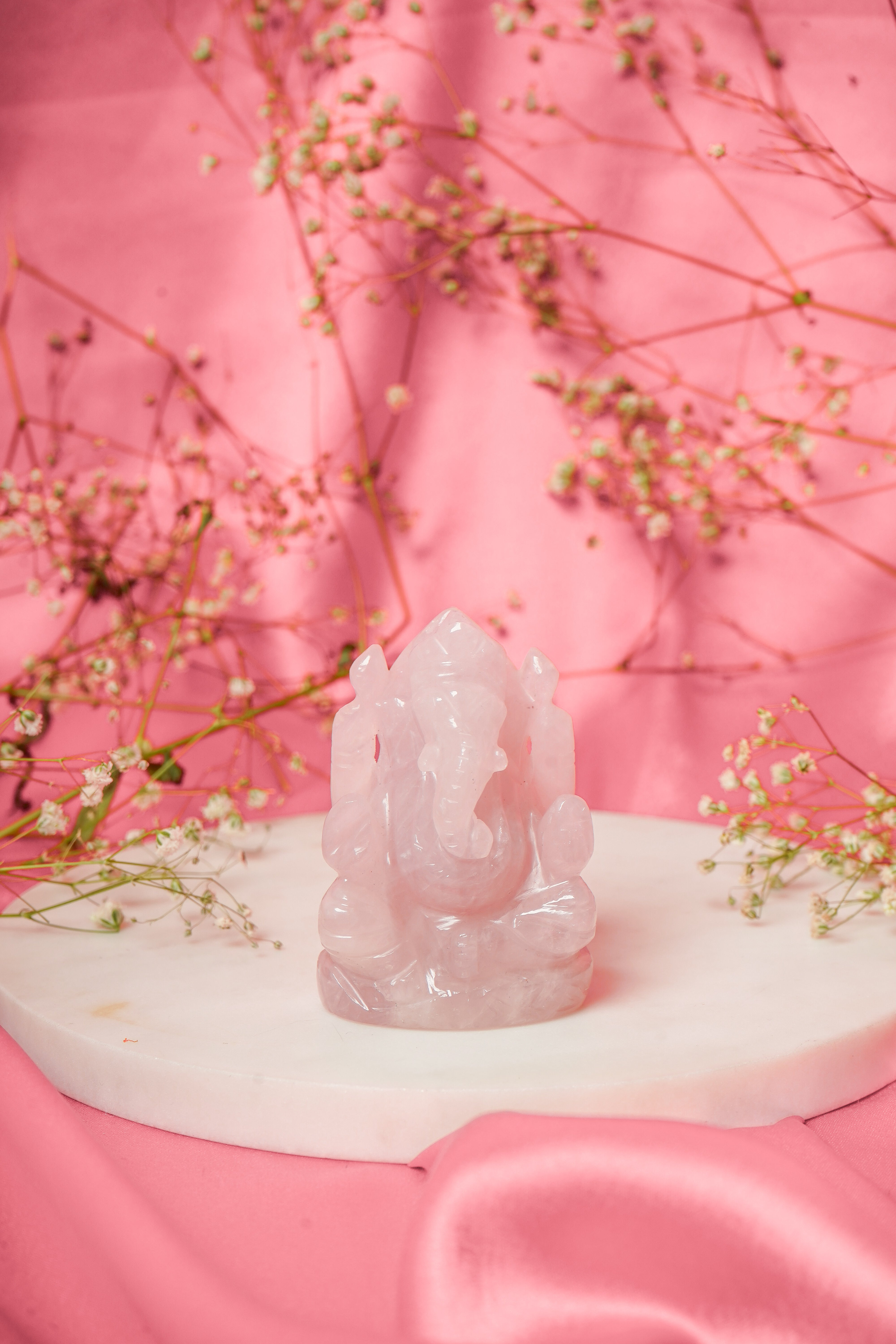 Natural rose quartz Ganesh Ji sculpture with detailed carvings, symbolizing prosperity and spiritual growth.