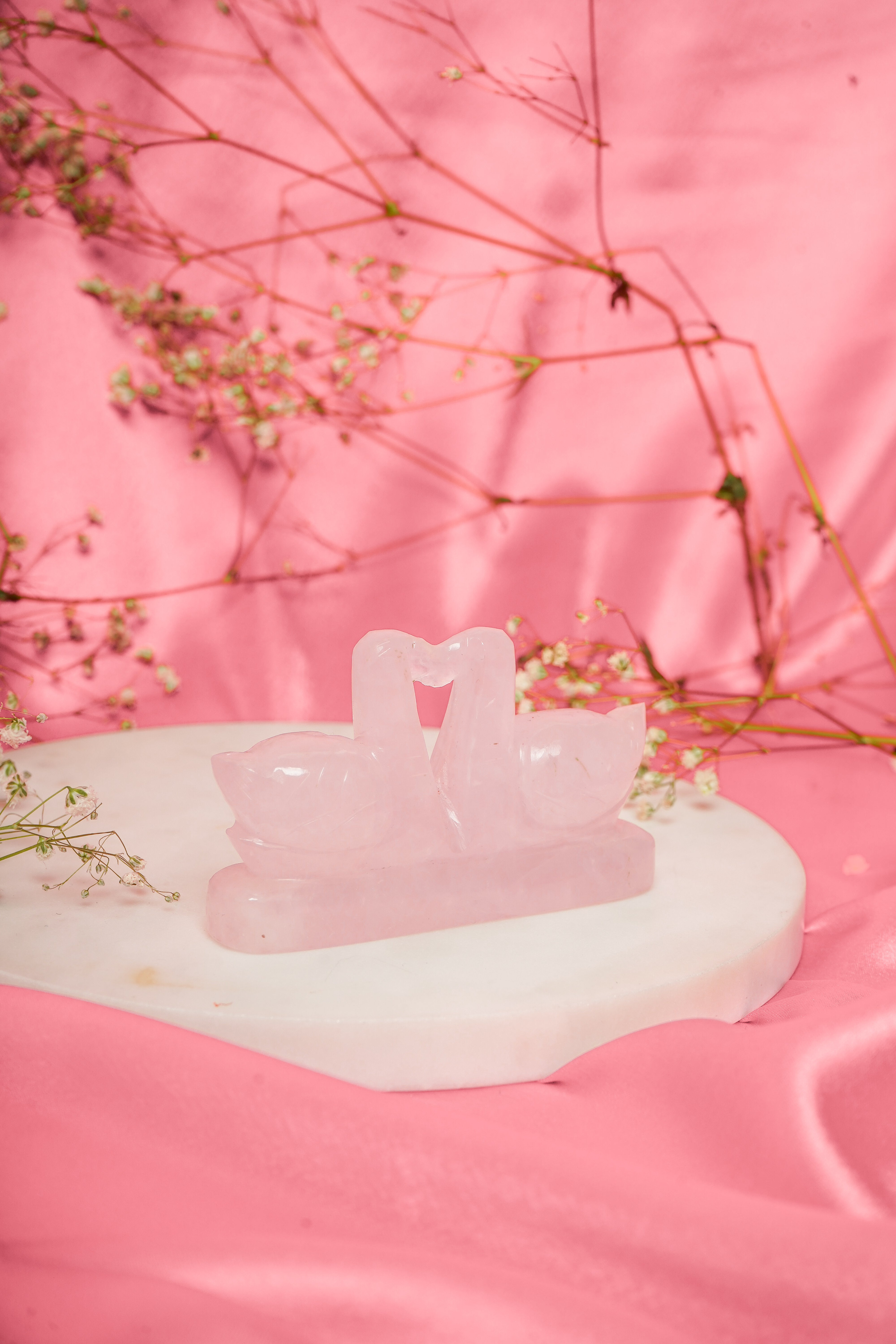 Pair of natural rose quartz swan figurines with smooth, polished surfaces and delicate carved details, ideal for decor and gifting.