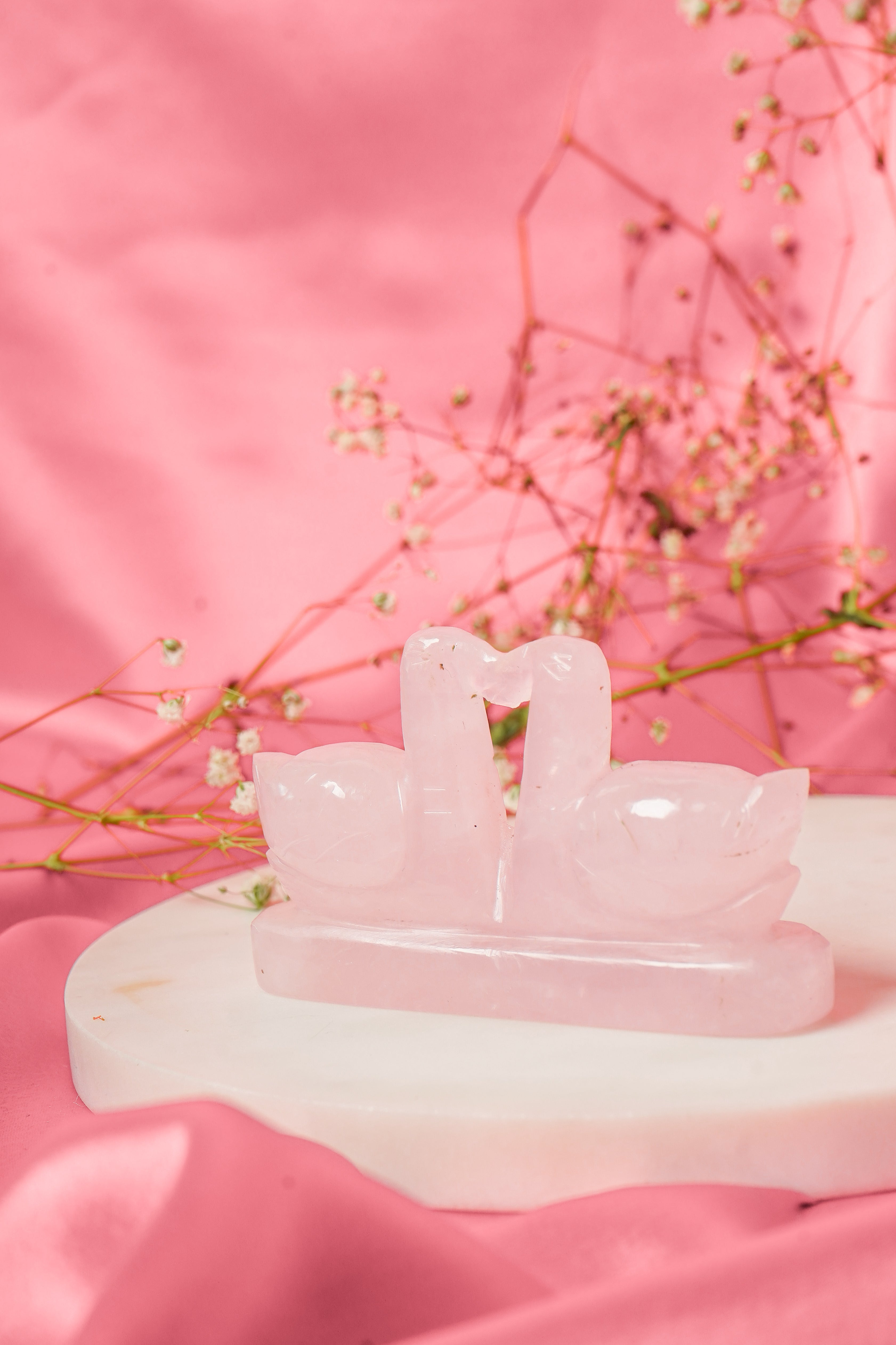 Pair of natural rose quartz swan figurines with smooth pink crystals, showcasing elegant, detailed craftsmanship.