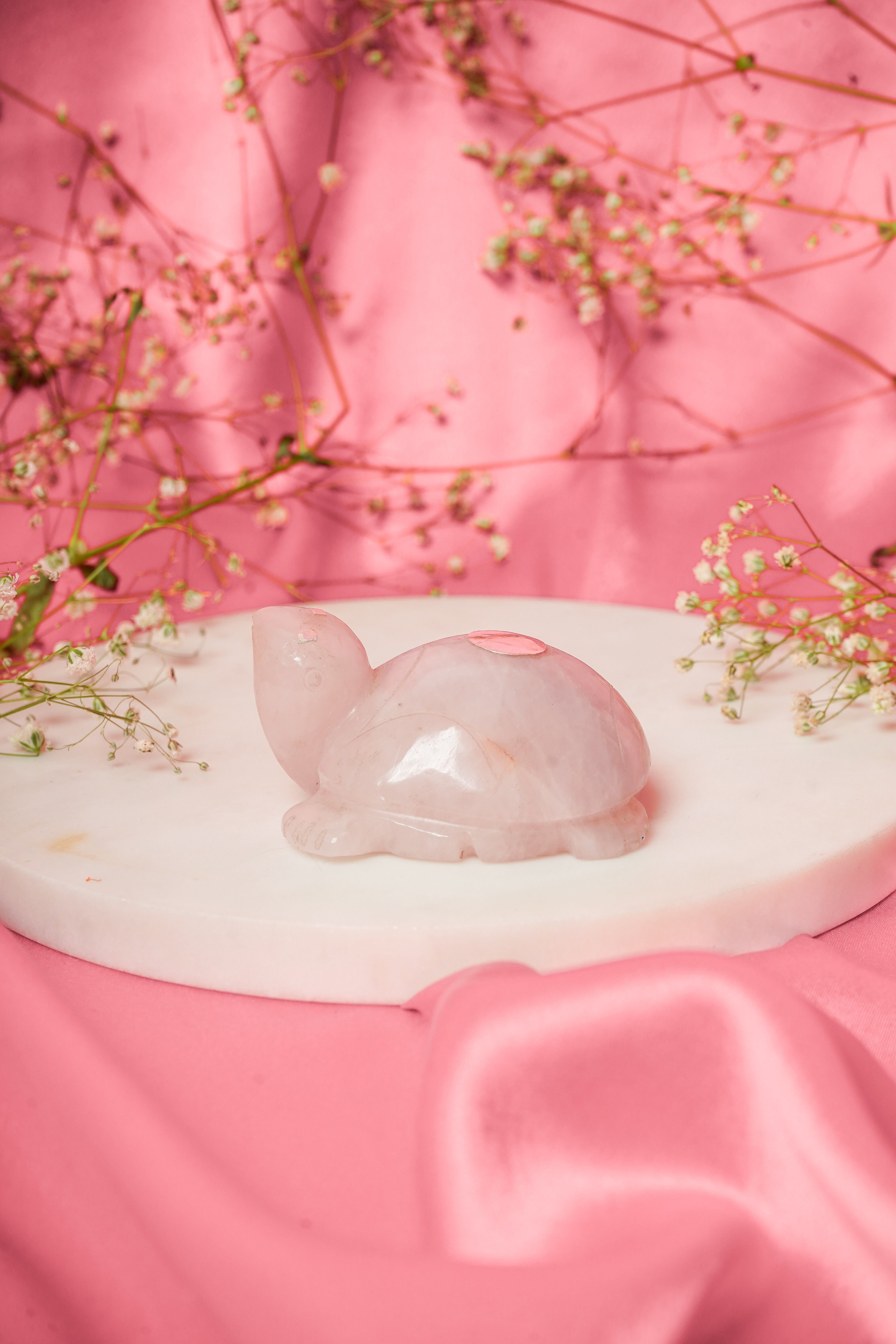 Natural rose quartz tortoise figurine with silver accents, showcasing a smooth polished surface and detailed carved features.