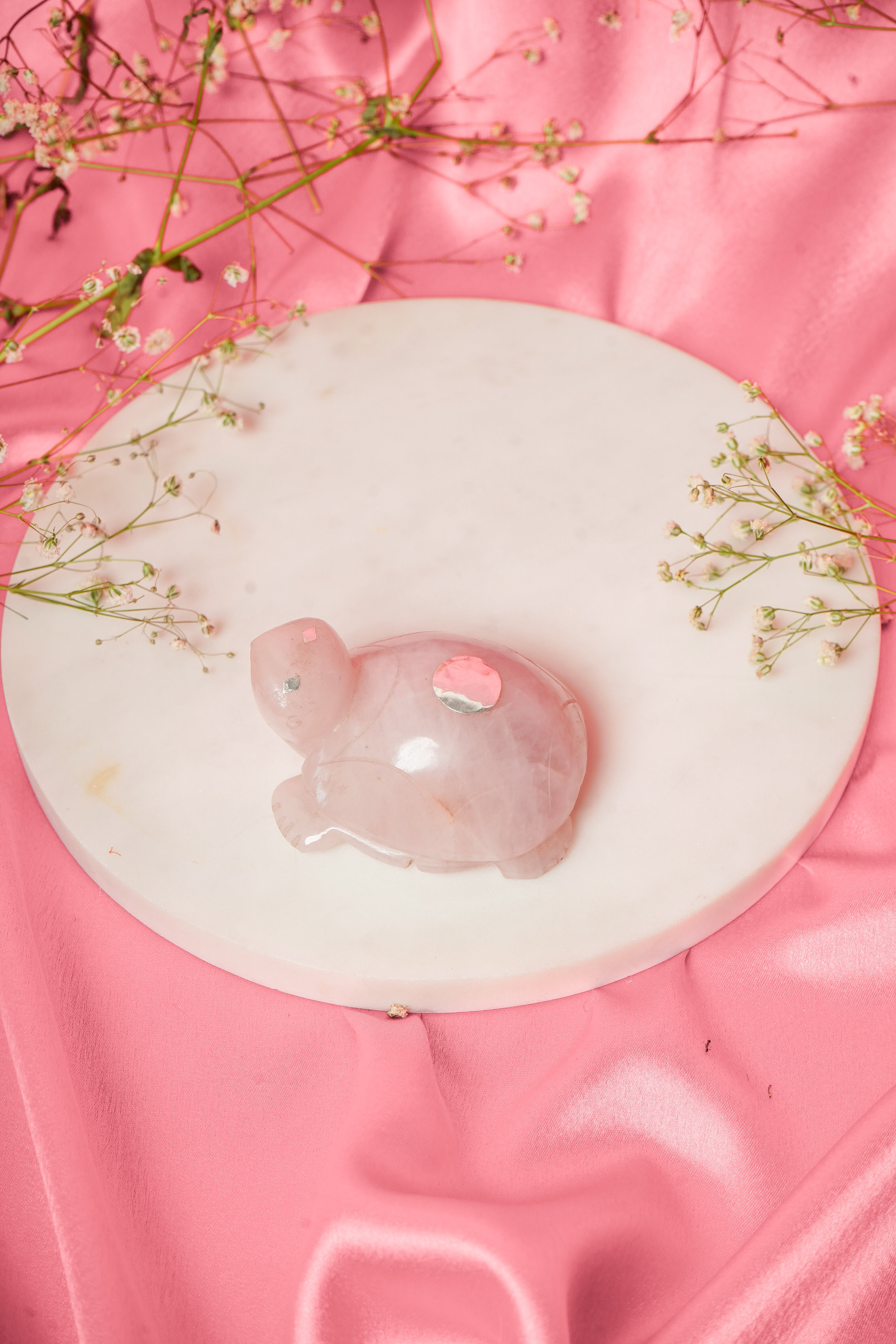 Natural rose quartz tortoise figurine with silver accents, showcasing smooth polished surface and detailed carvings.