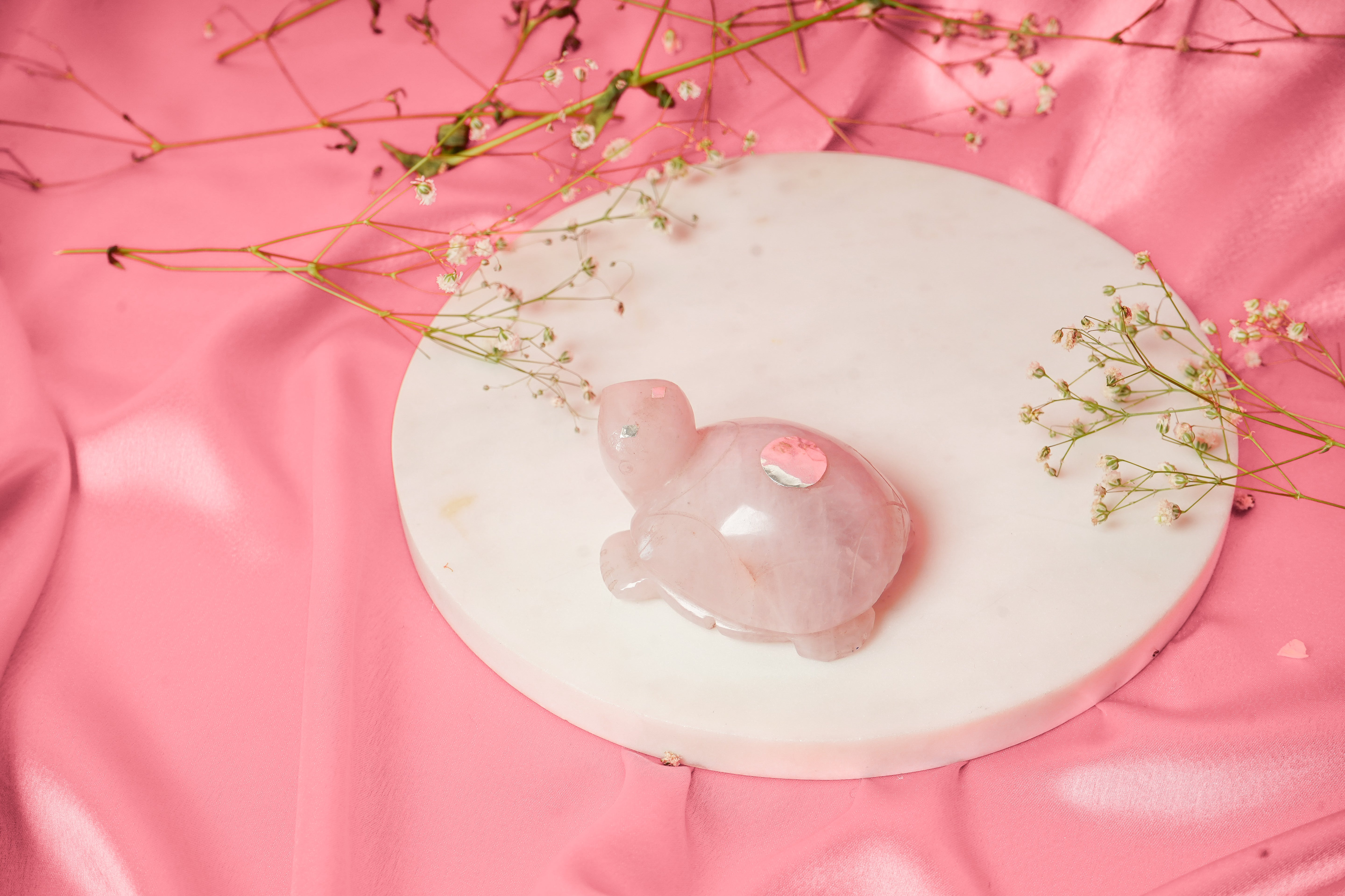 Natural rose quartz tortoise figurine with silver accents, showcasing a smooth, polished surface and intricate detailing.