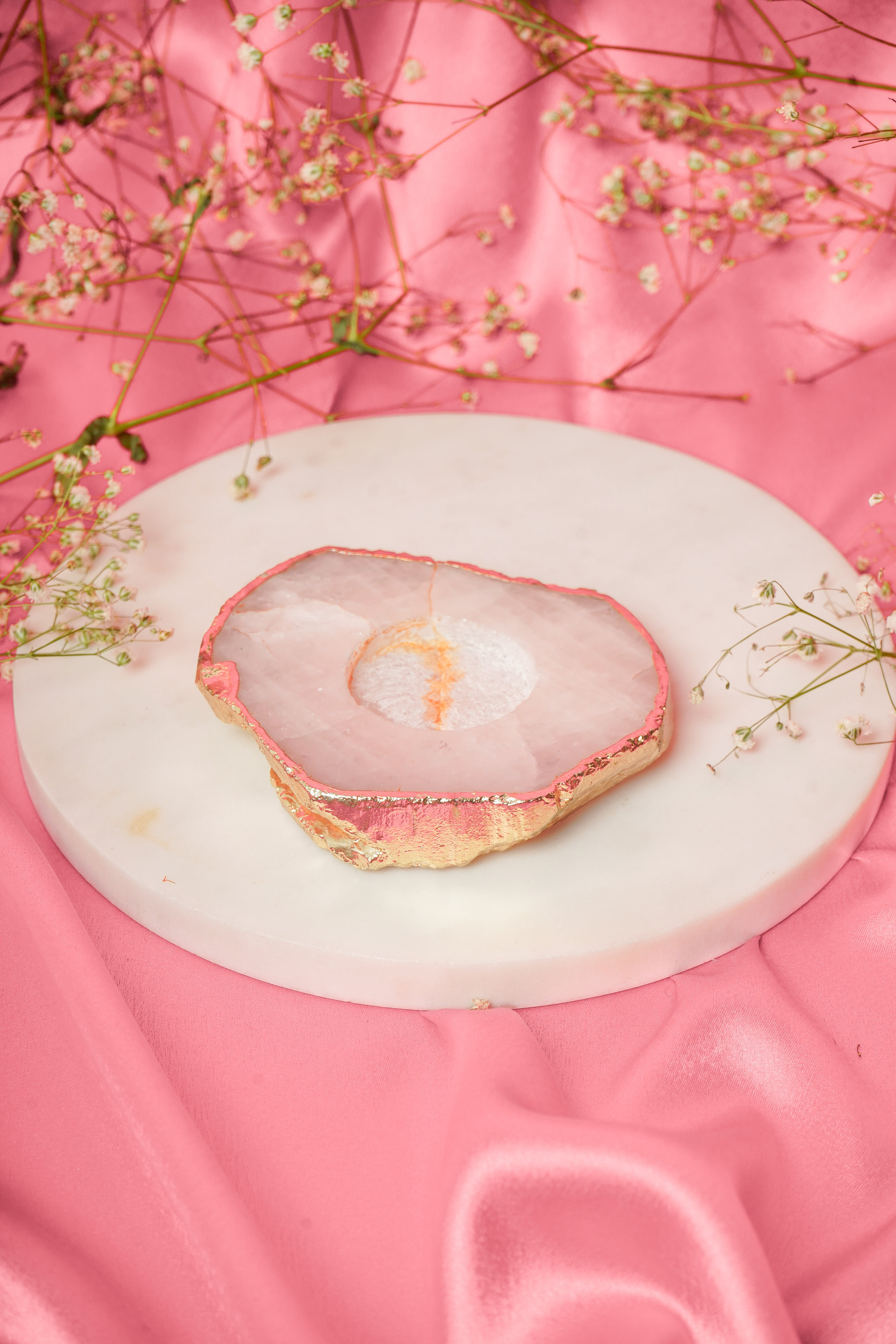 Natural rose quartz tea light candle from Rasava Jewels, showcasing a smooth, polished pink gemstone with a small candle holder.