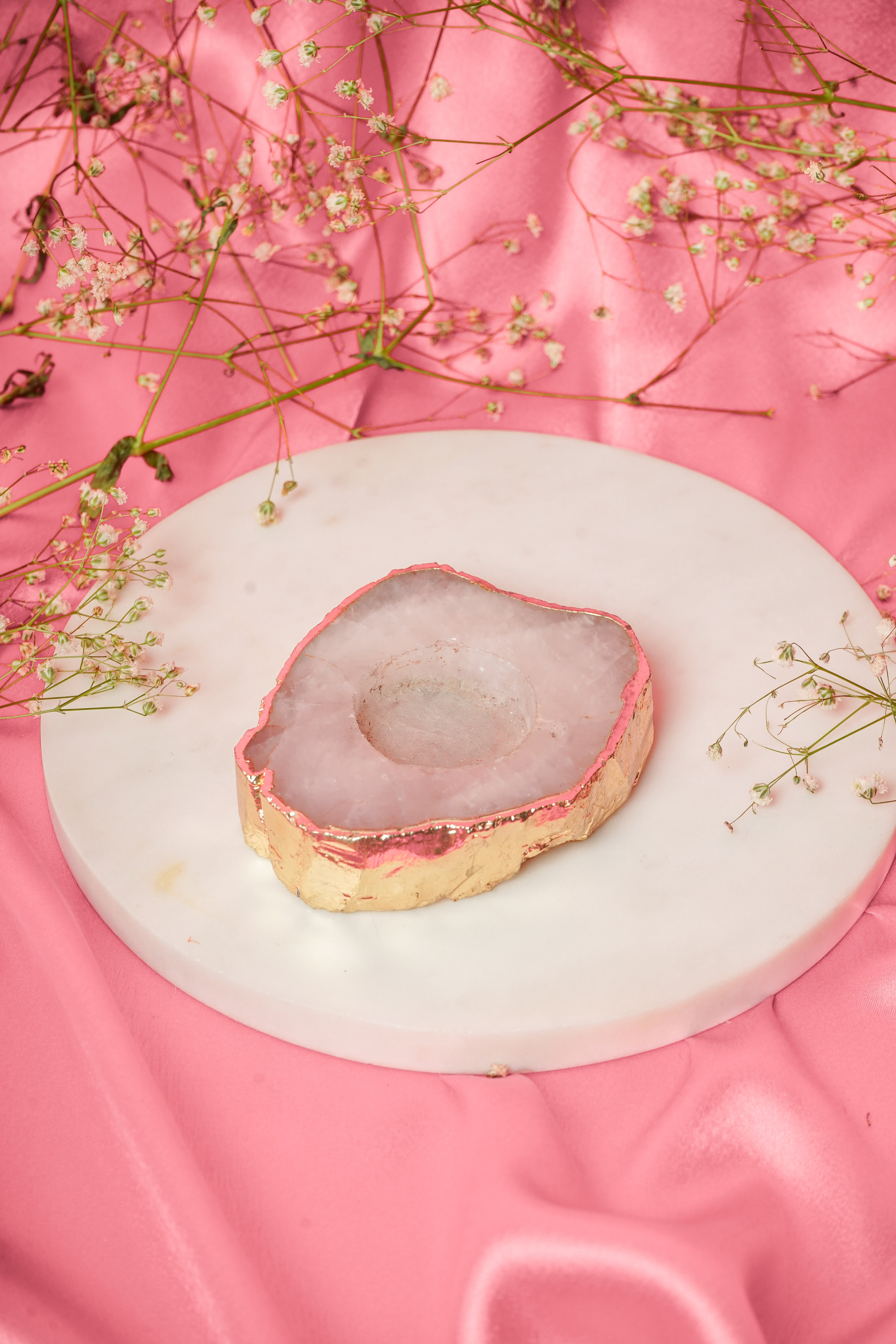 Natural rose quartz tea light candle by Rasava Jewels, showcasing a smooth, polished pink crystal with a small candle holder.
