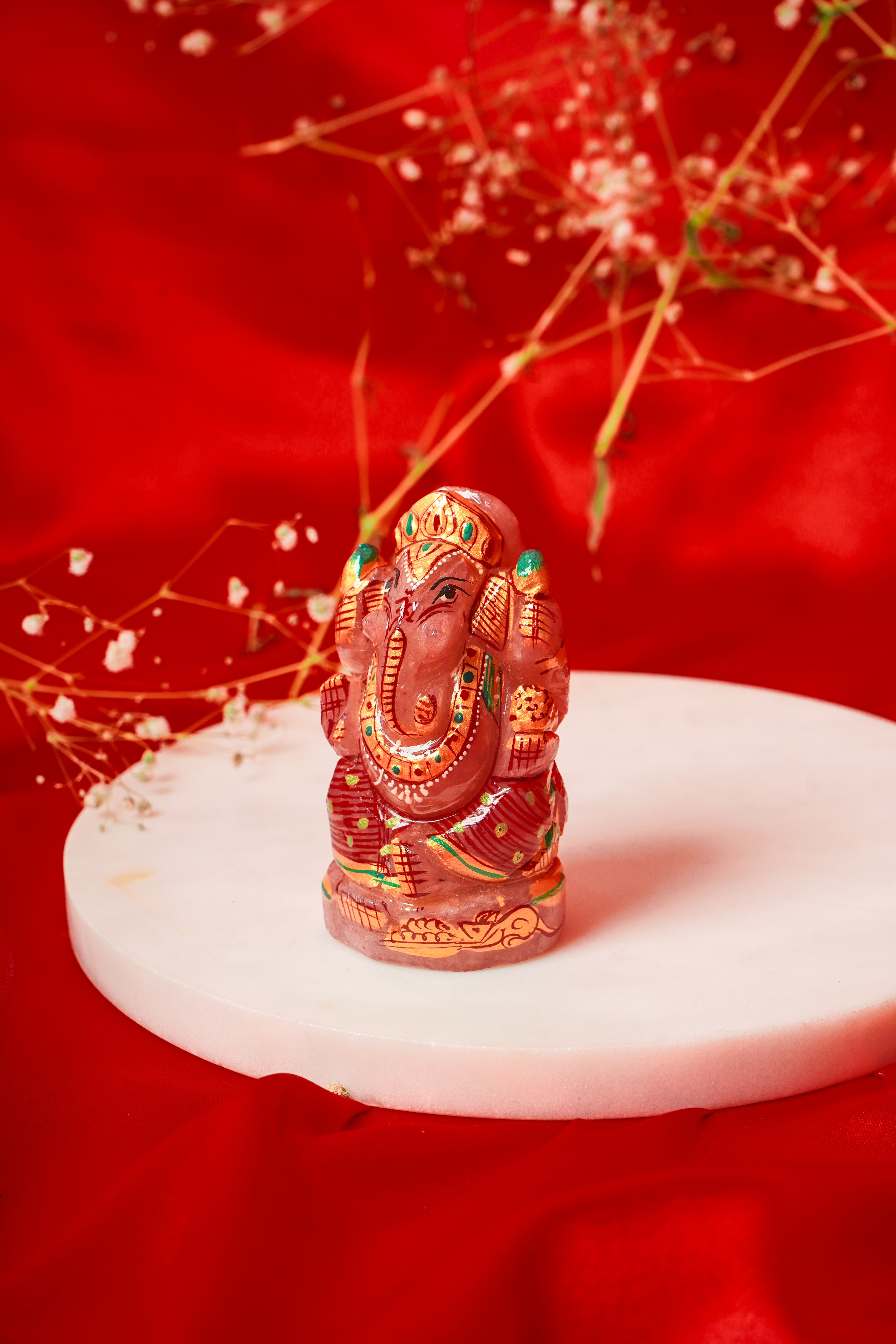 Natural rose quartz Ganesh Ji statue with Meenakari detailing, showcasing intricate craftsmanship and vibrant colors.