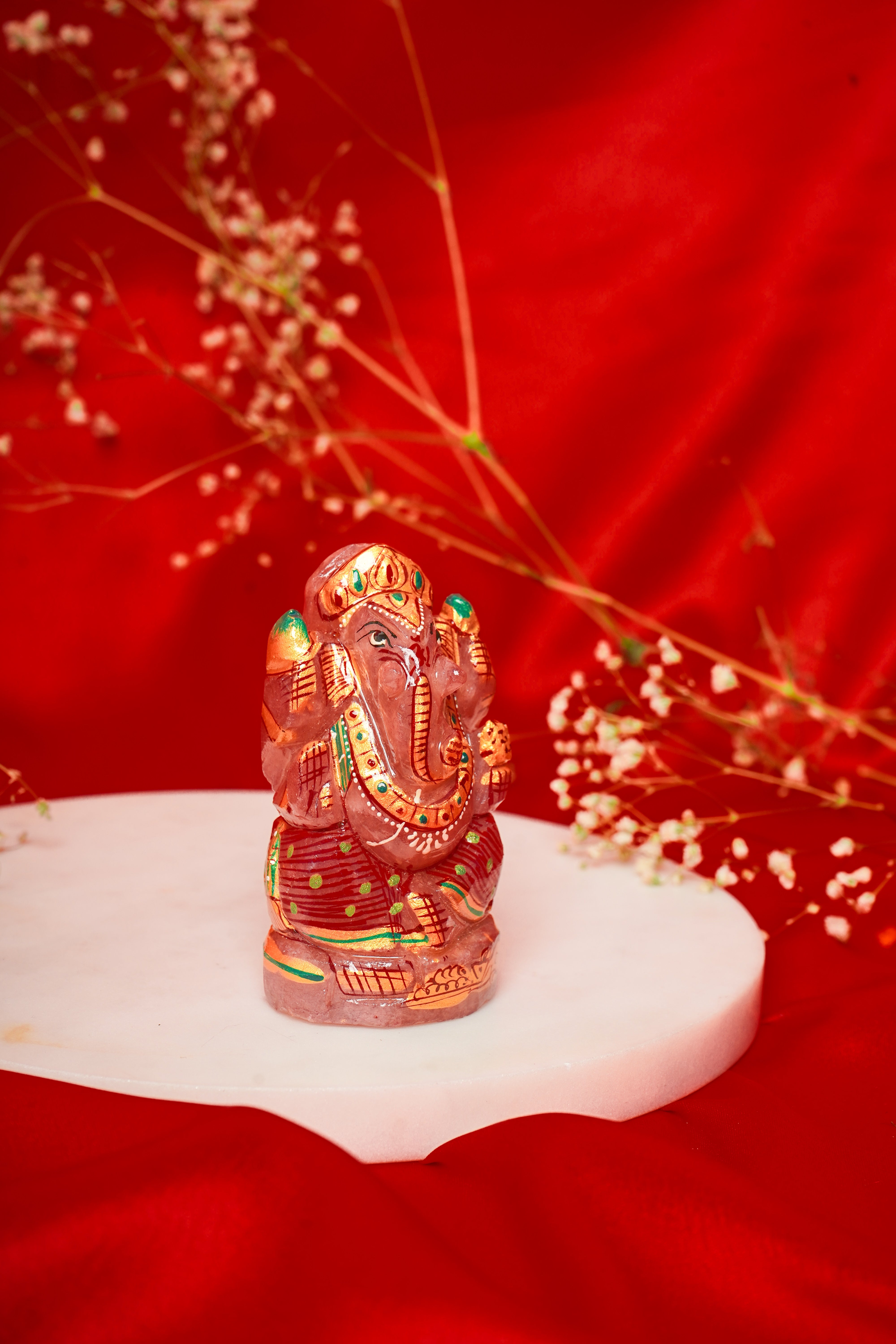 Natural rose quartz Ganesh Ji figurine with meenakari detailing, crafted for spiritual and decorative use.