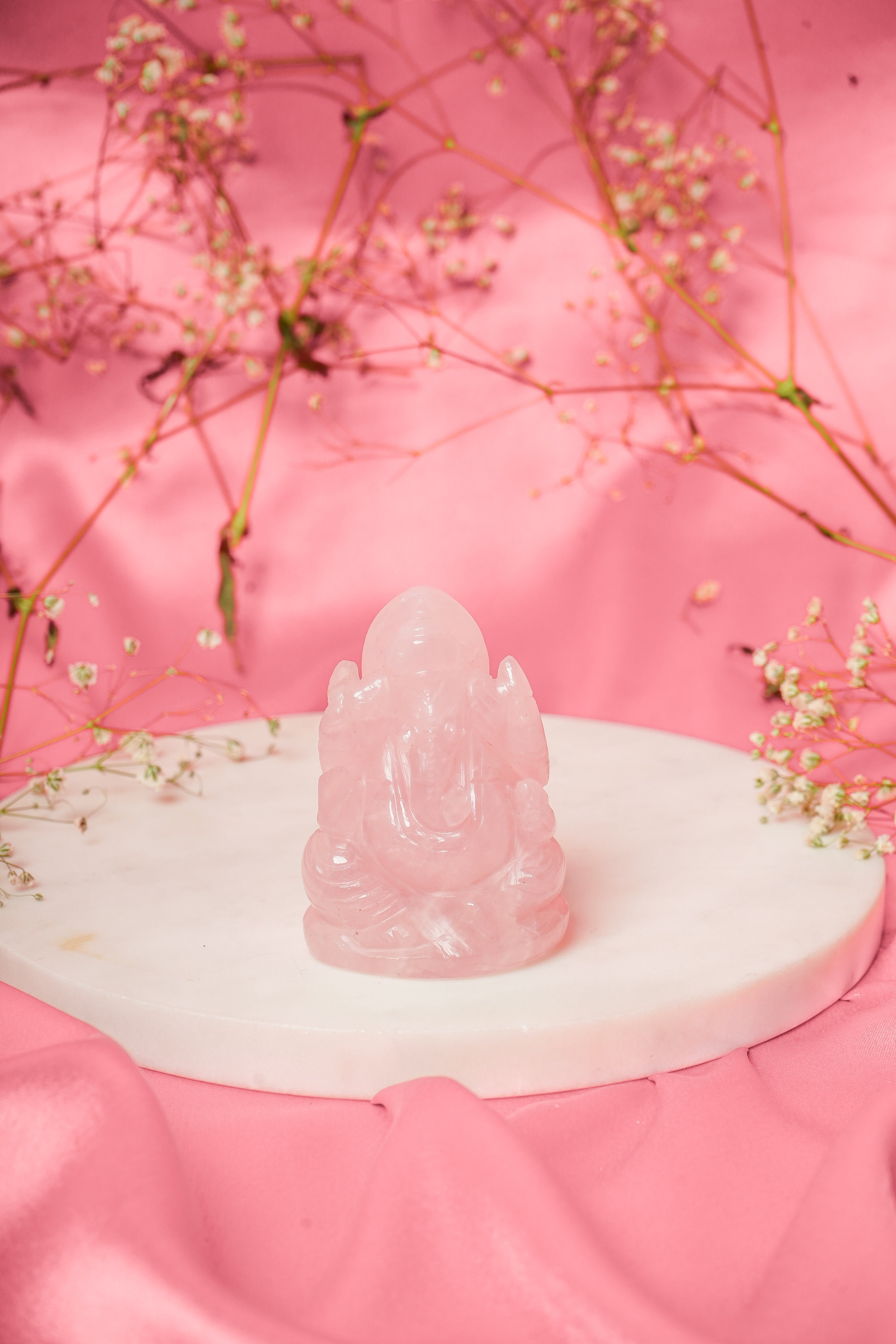 Natural rose quartz Ganesh ji statue with detailed carvings, showcasing a serene and spiritual figure for home decor.