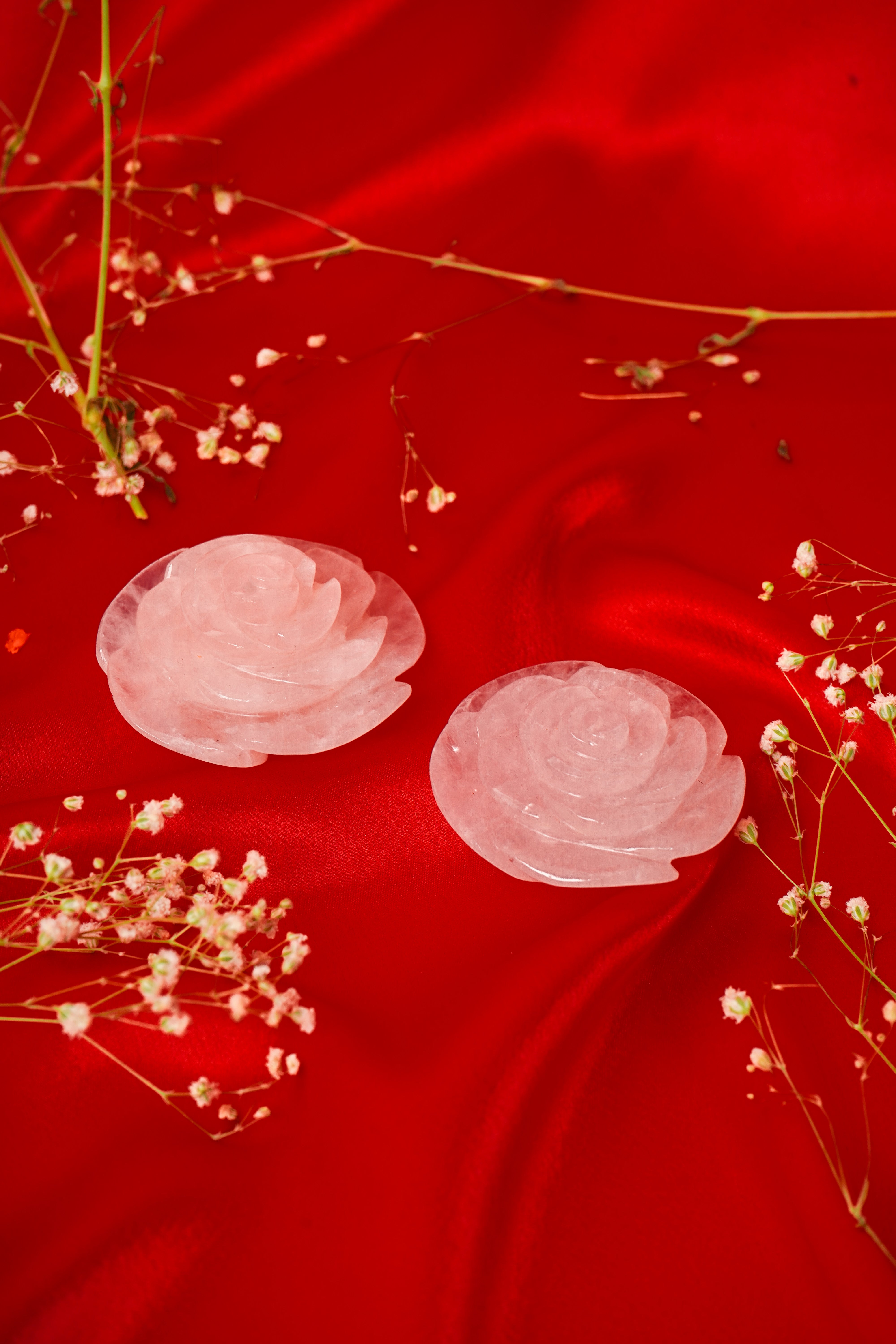 Pair of natural rose quartz rose flowers with pink crystal petals, showcasing their delicate, polished appearance and soft color.