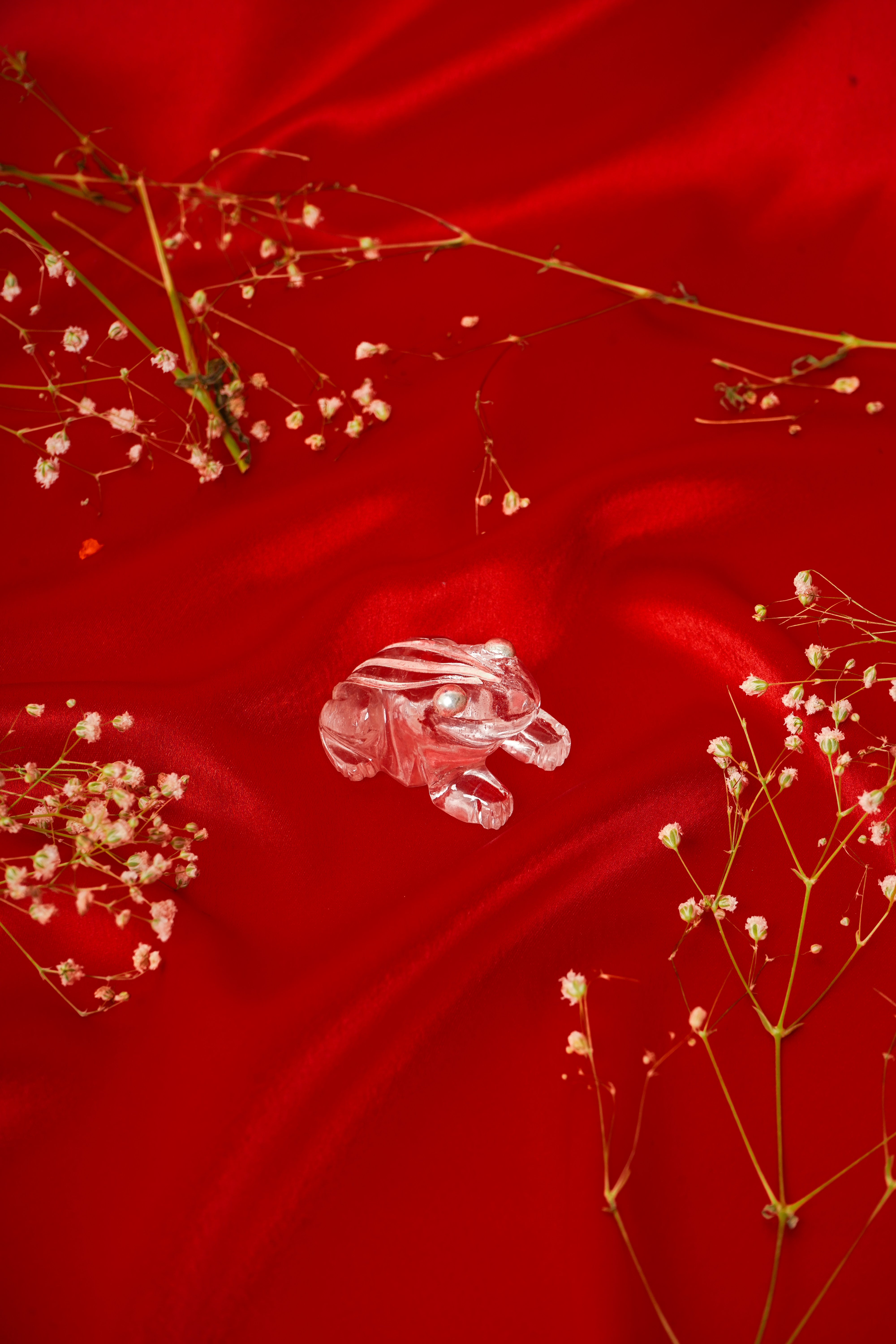 Natural clear quartz frog sculpture with silver accents, showcasing detailed craftsmanship and smooth, polished surface.