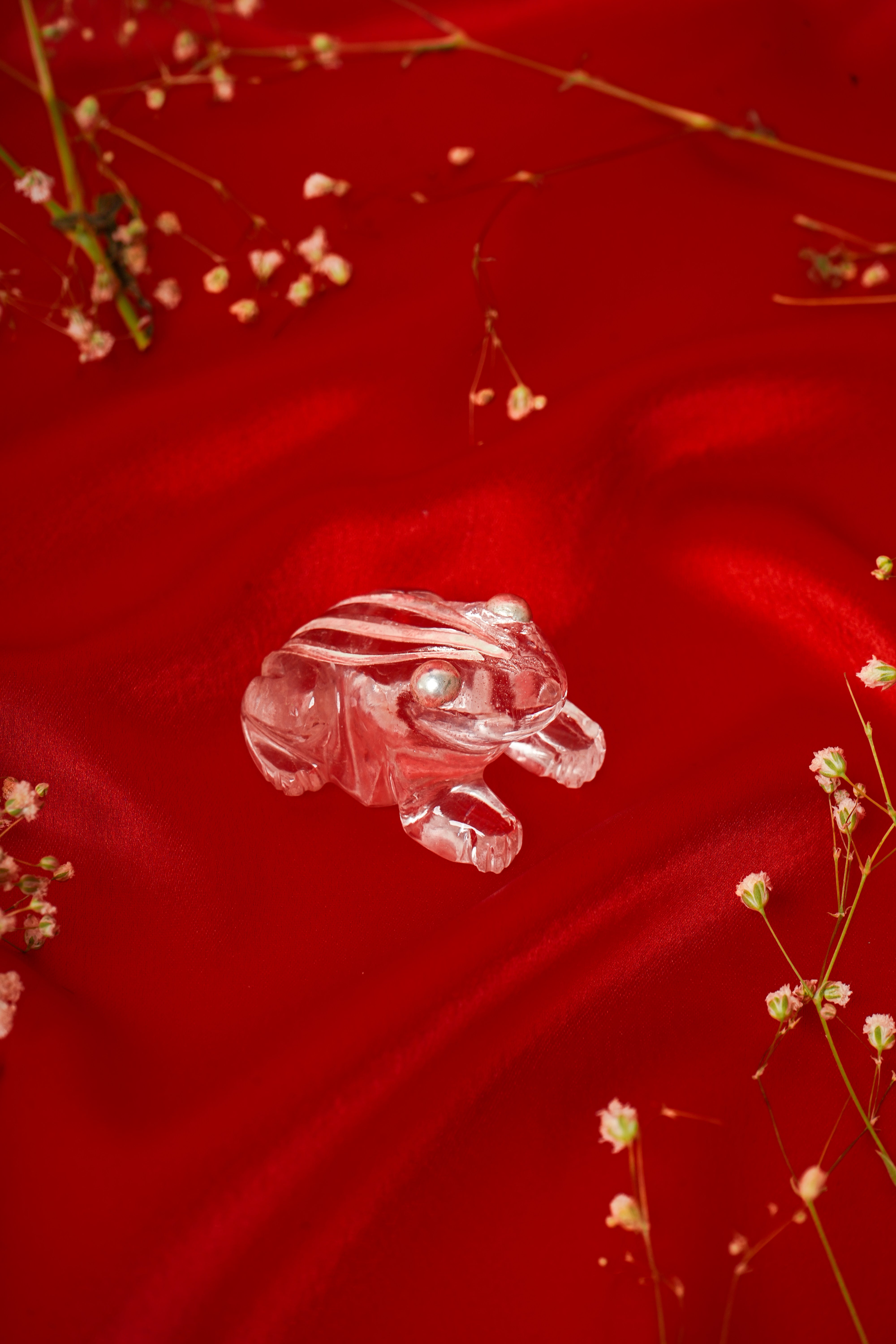 Natural clear quartz frog sculpture with silver accents, showcasing detailed craftsmanship and polished stone features.
