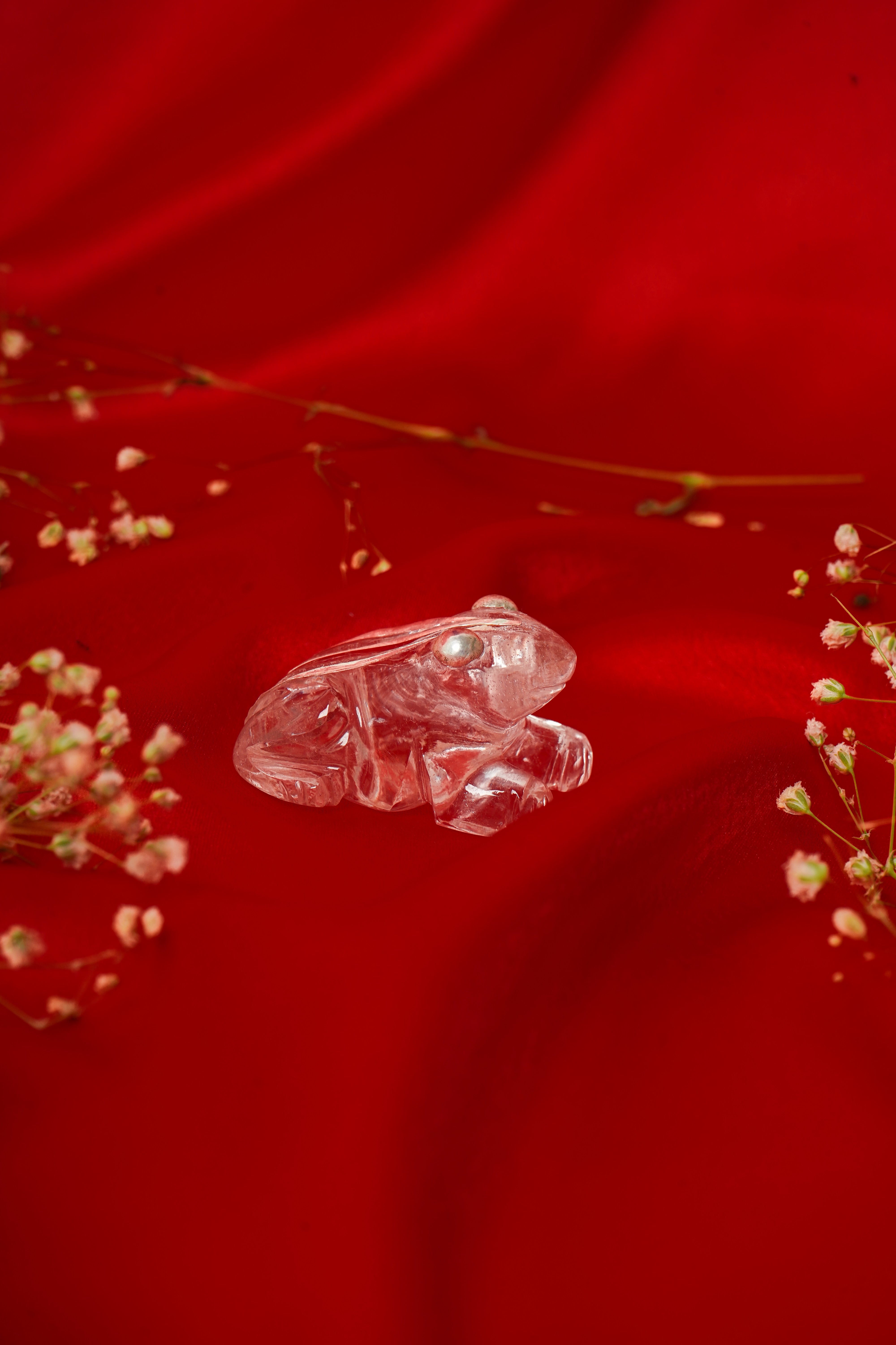 Natural clear quartz frog sculpture with silver accents, featuring detailed craftsmanship and smooth, polished surface.