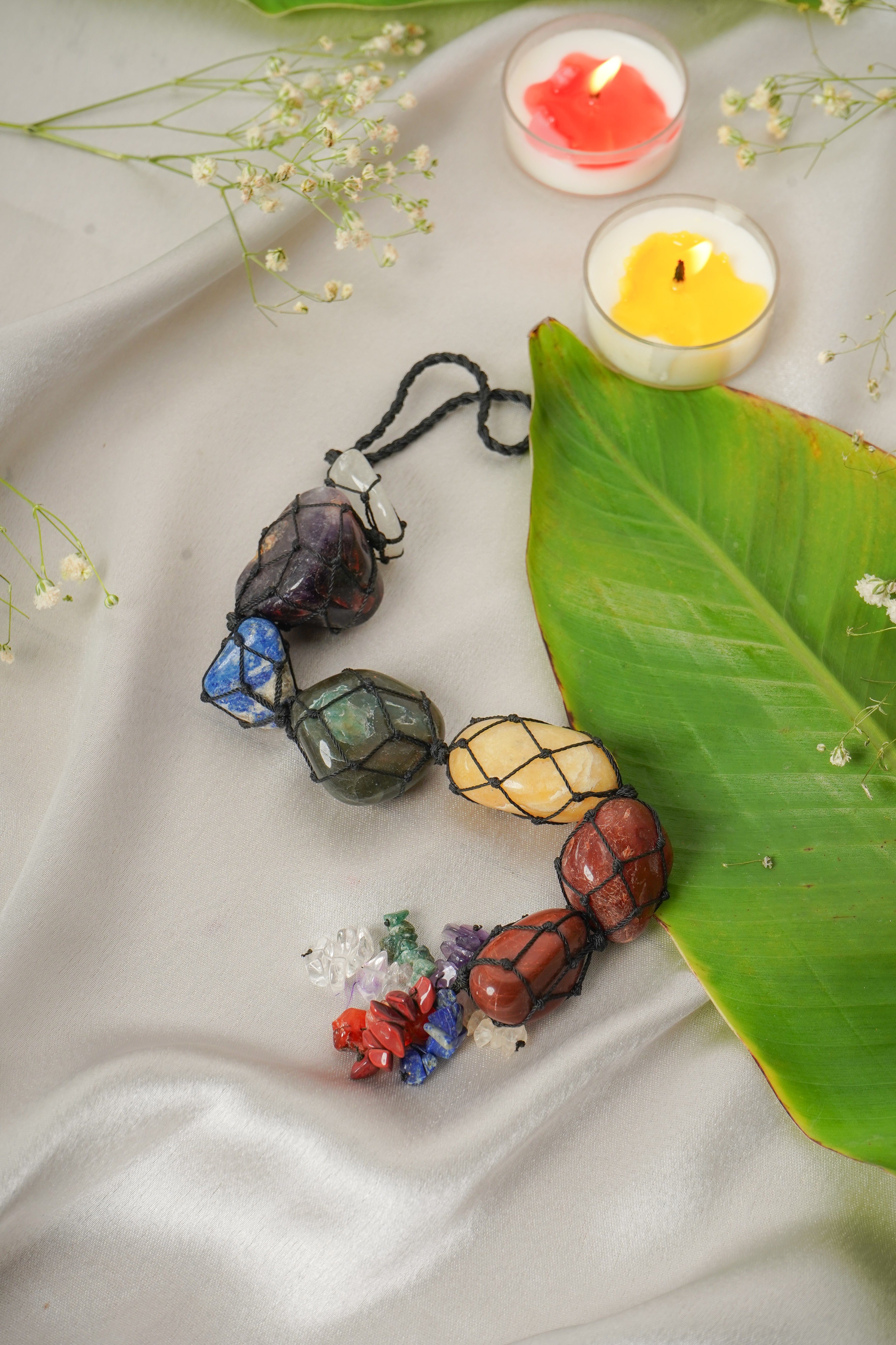 Seven chakra natural stone wall hanging with colorful stones and intricate design, ideal for spiritual or decorative wall decor.