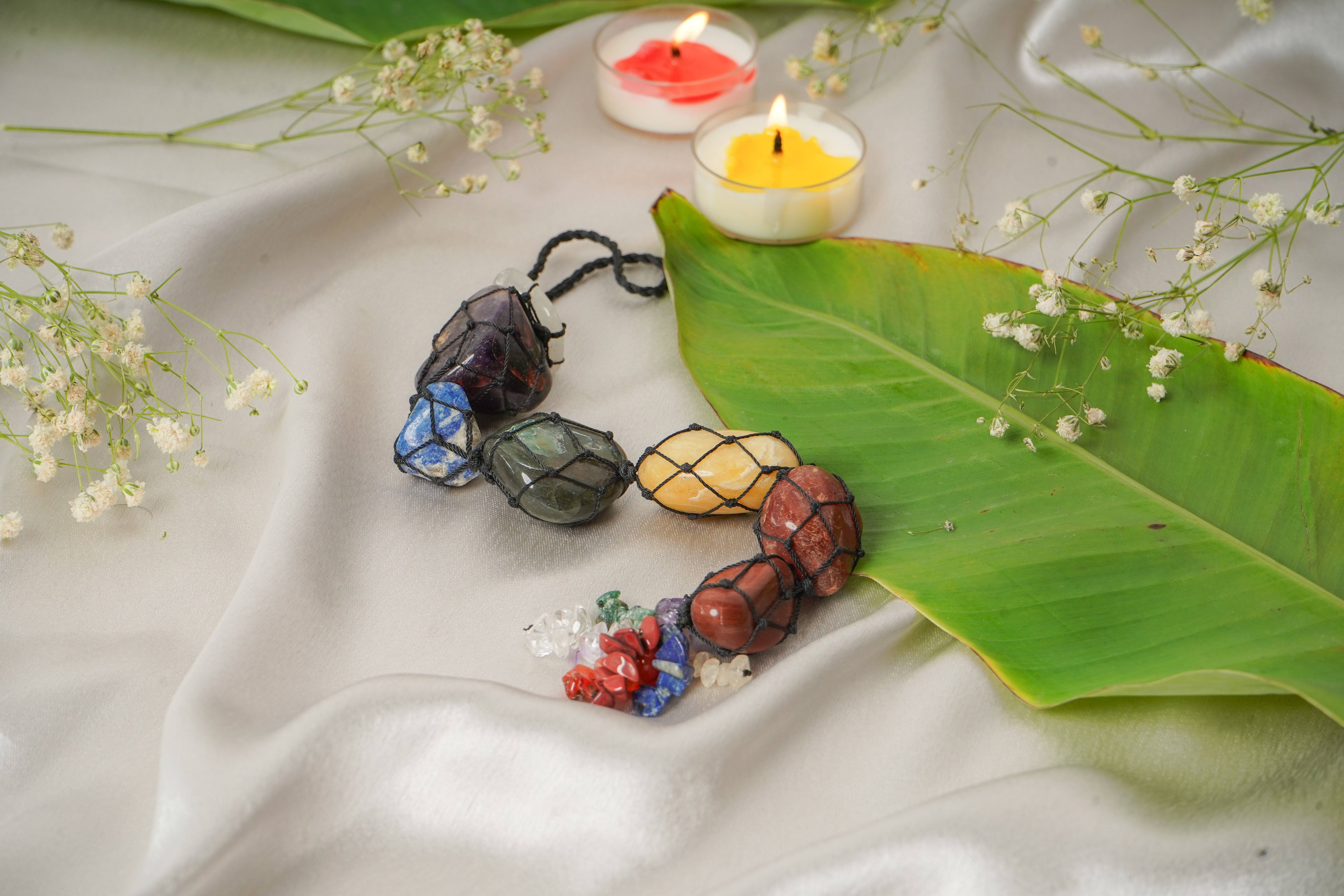 Seven chakra natural stone wall hanging featuring colorful stones and intricate design for spiritual decor.