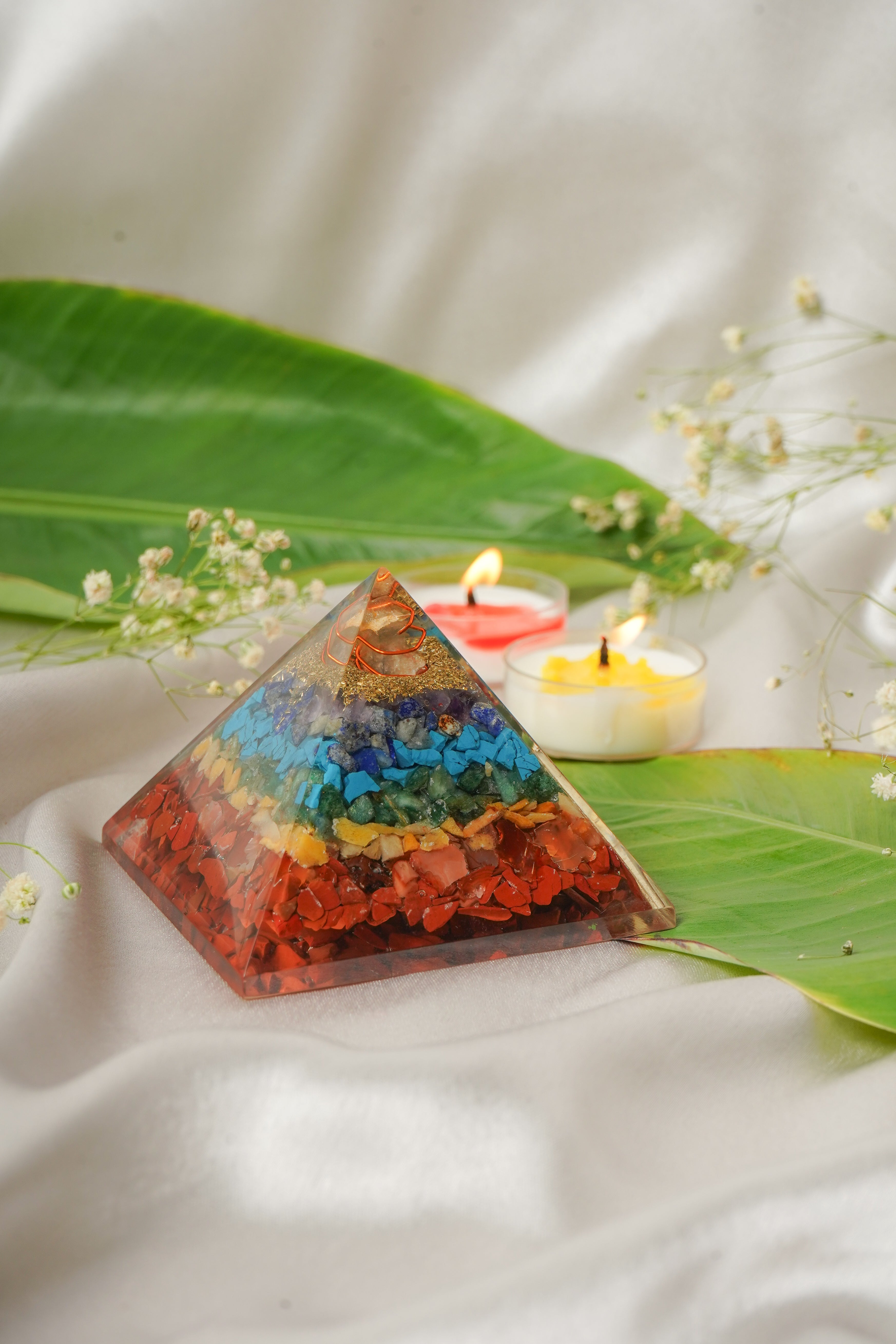 Seven chakra natural stone pyramid with colorful polished stones, representing the seven chakras in a geometric pyramid shape.