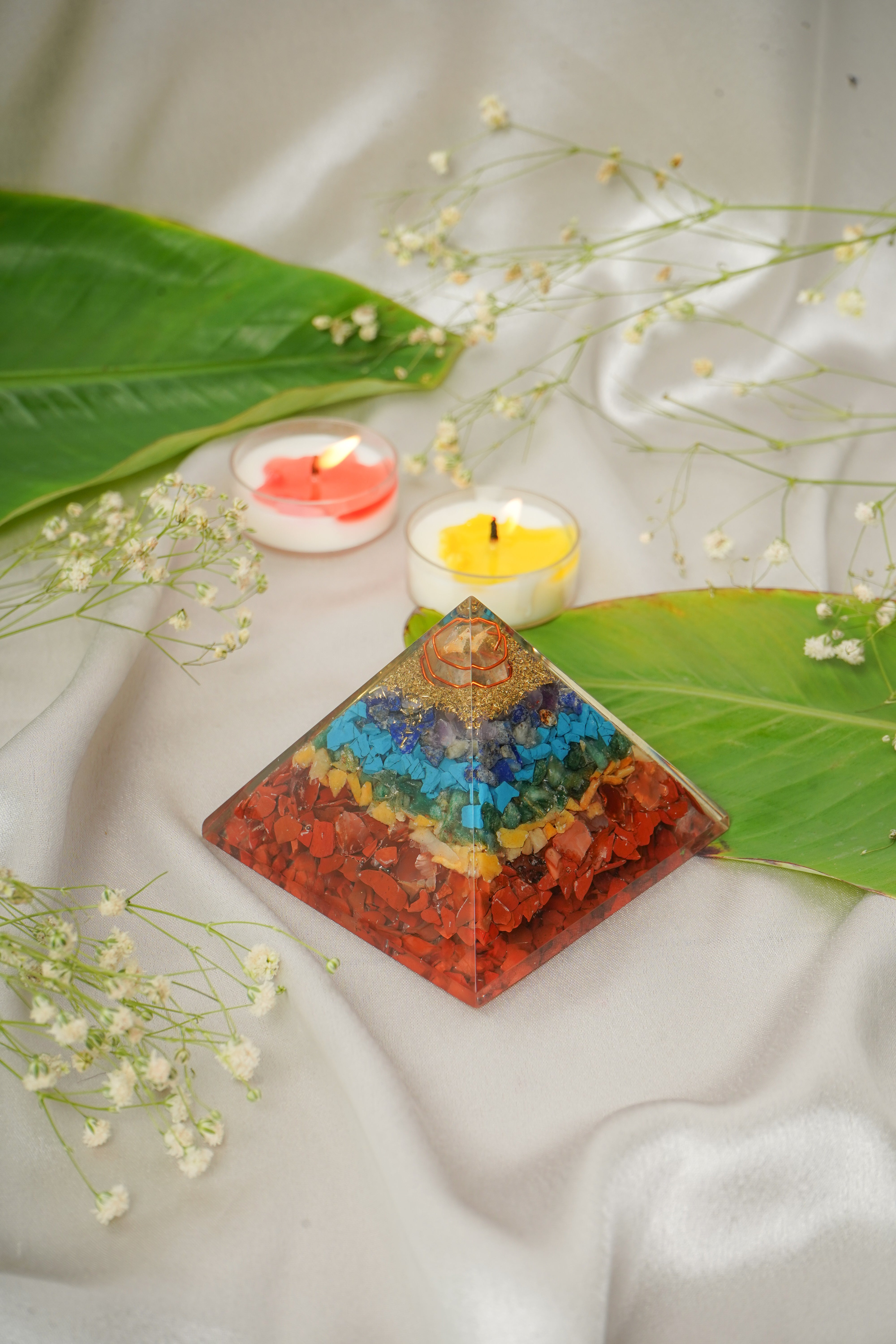 Seven chakra natural stone pyramid with colorful chakra stones arranged in a pyramid shape, showcasing vibrant gemstone colors.