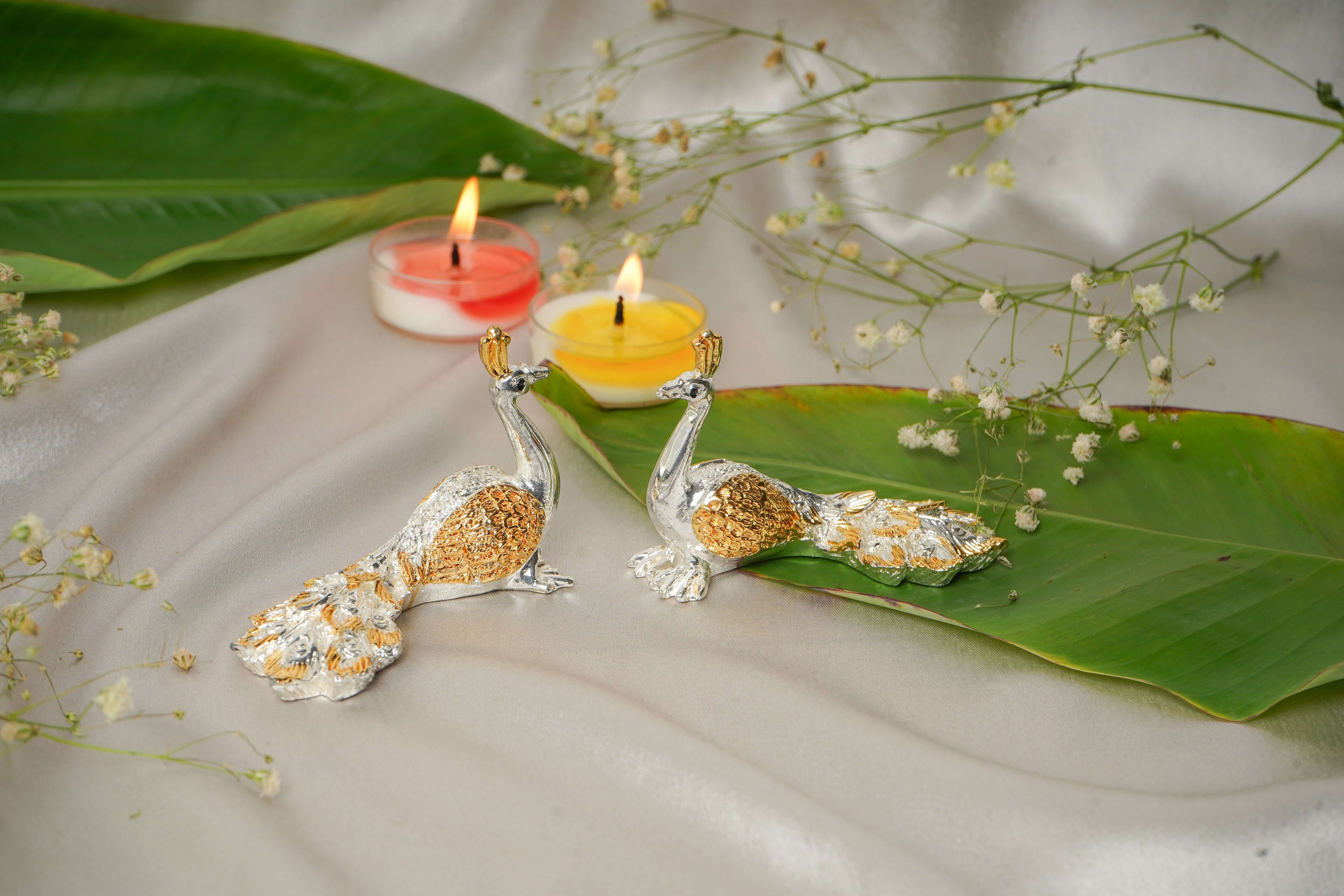 Silver and gold plated peacock earrings pair with intricate feather details, showcasing elegant jewelry craftsmanship.