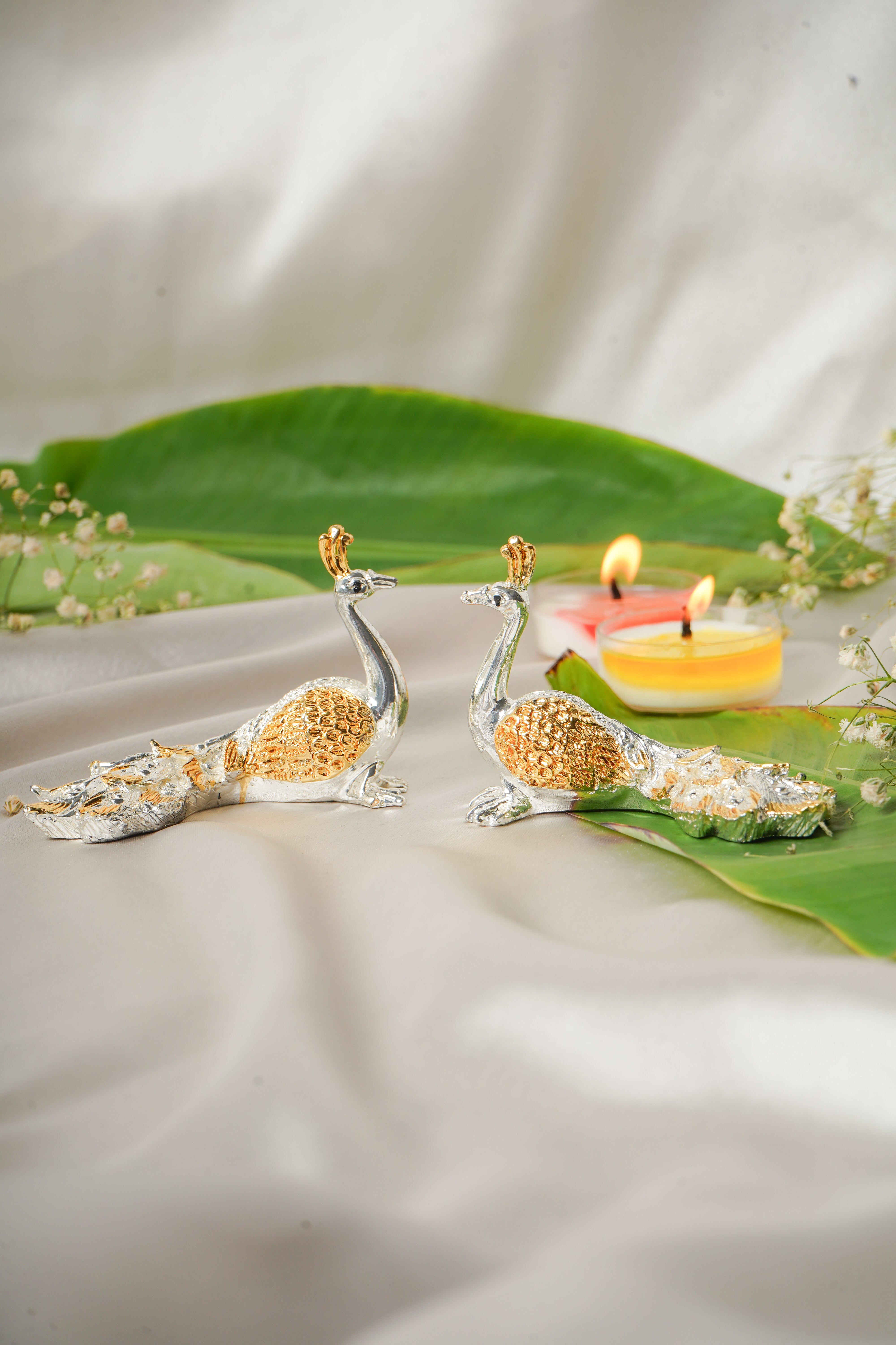 Silver and gold plated peacock earrings featuring intricate feather details, showcasing elegant jewelry craftsmanship.