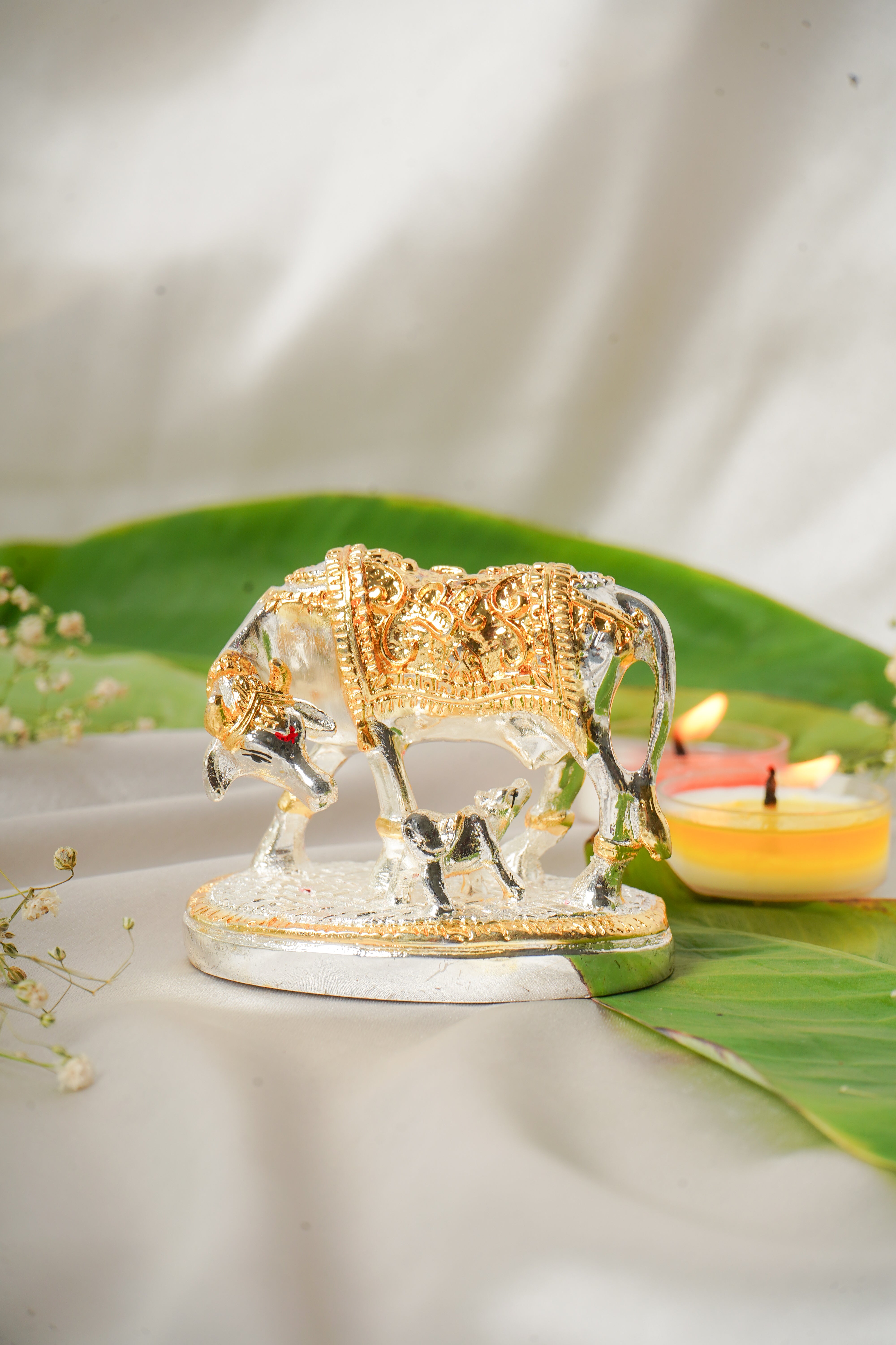 Silver and gold plated cow figurine with detailed features, showcasing a realistic and polished appearance.