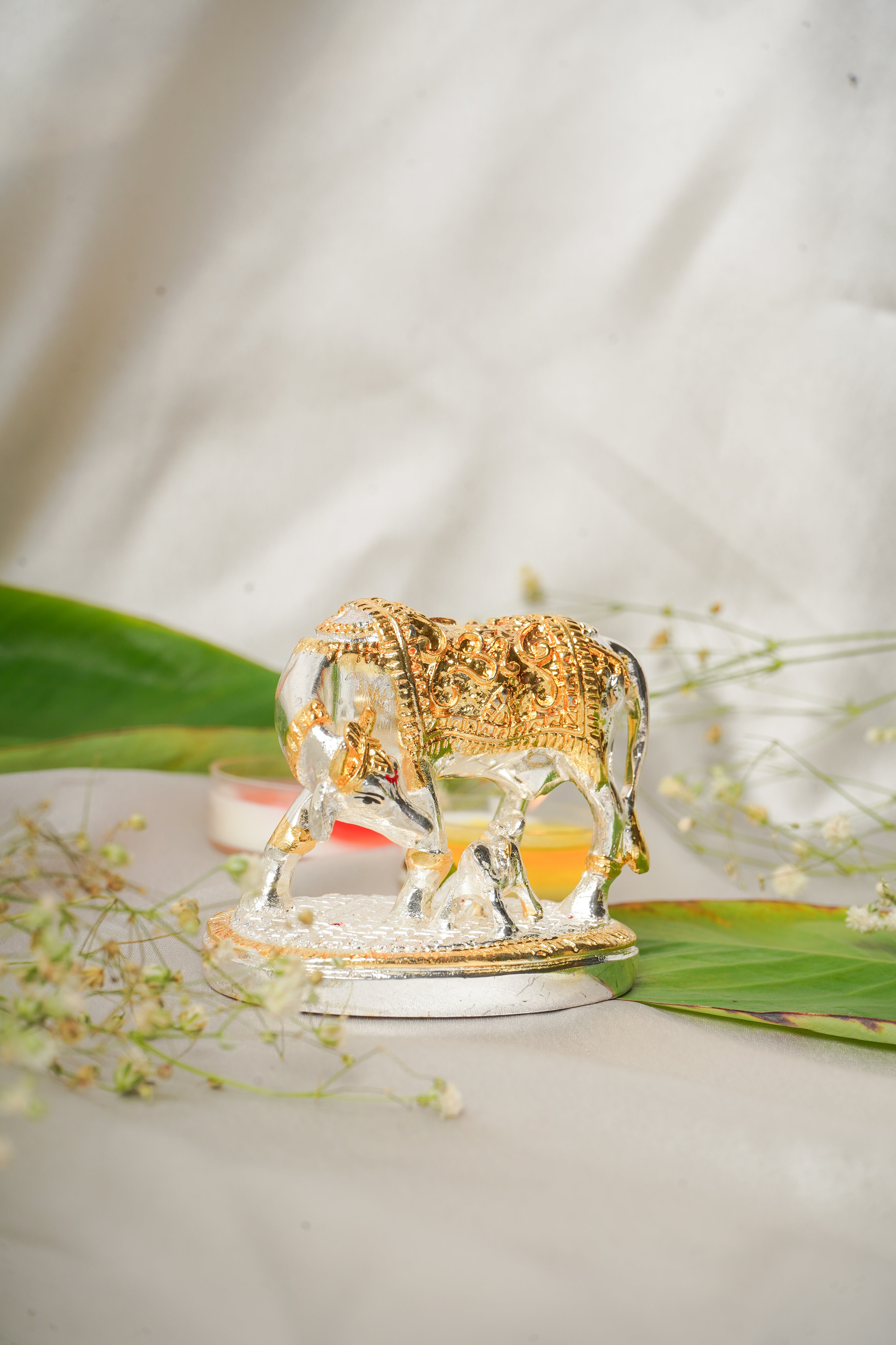 Silver and gold plated cow figurine with detailed craftsmanship, showcasing a shiny, metallic finish and realistic animal features.