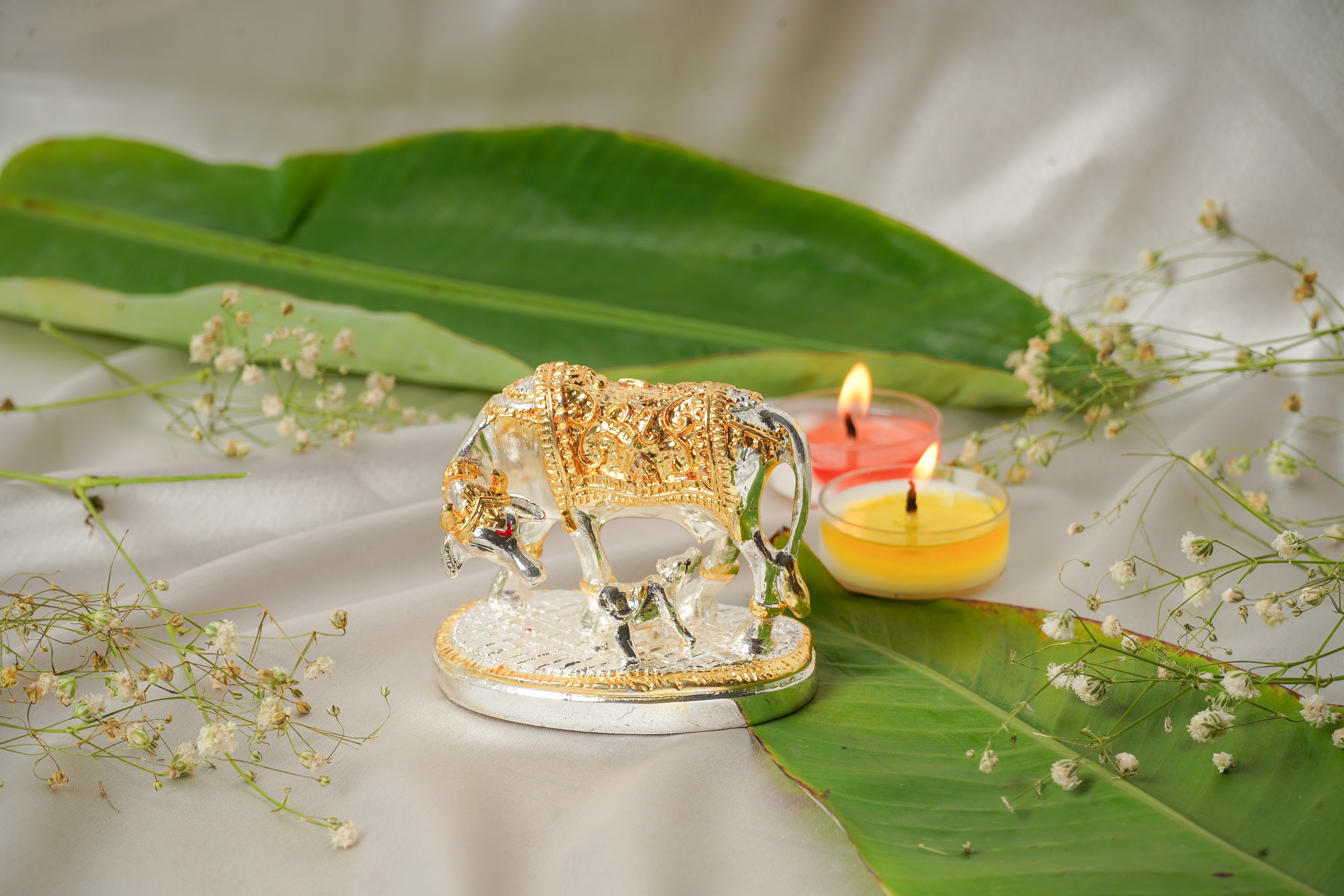 Silver and gold plated cow figurine with detailed features, showcasing a shiny metallic finish and realistic design.