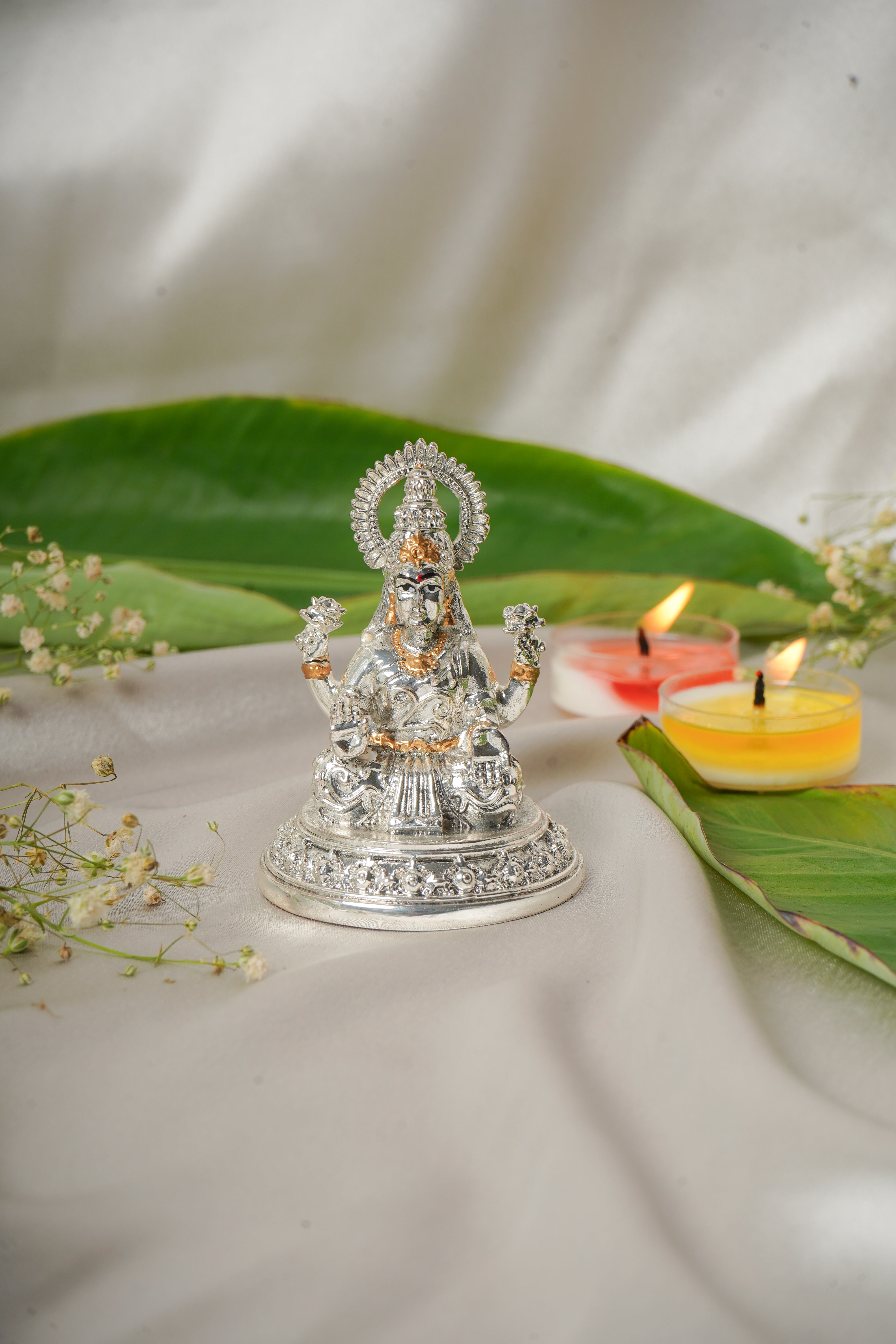 Silver and gold plated Lakshmi and Ganesh ji figurine, intricately detailed religious brass sculpture.
