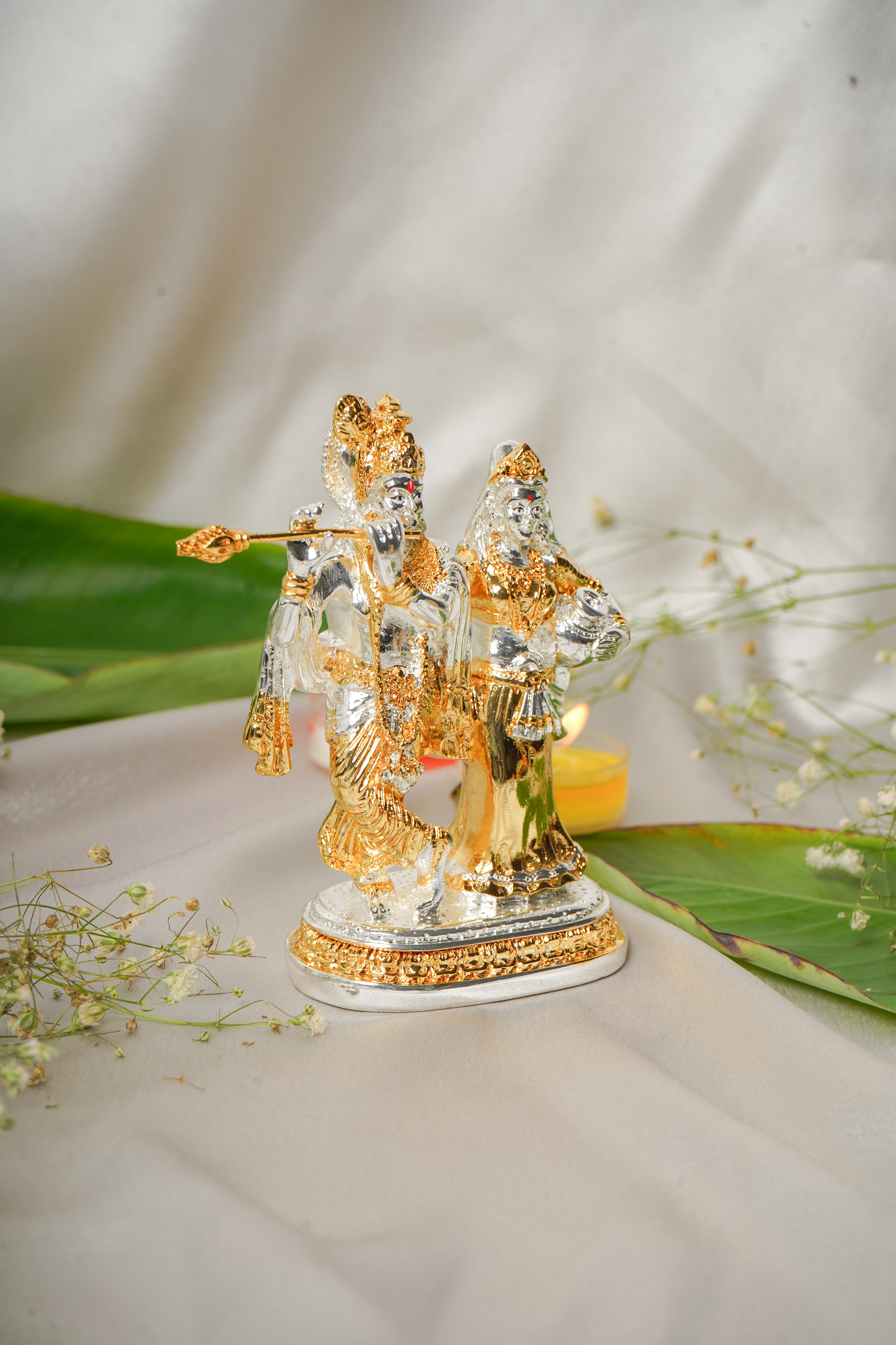 Silver and gold plated Radha Krishna idol with intricate detailing, showcasing divine figures in traditional attire.