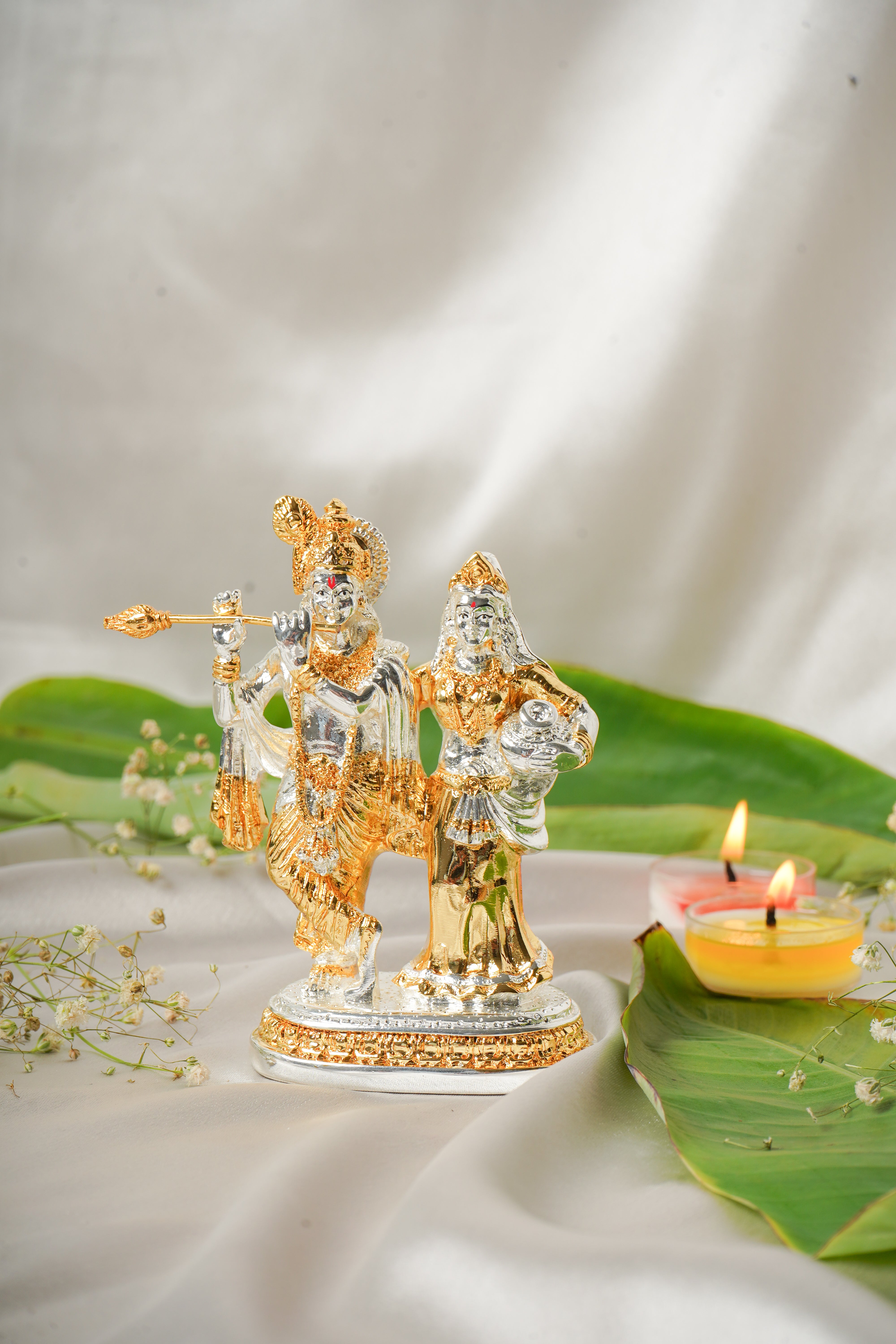 Silver and gold plated Radha Krishna idol, intricately detailed religious sculpture, showcasing traditional craftsmanship.