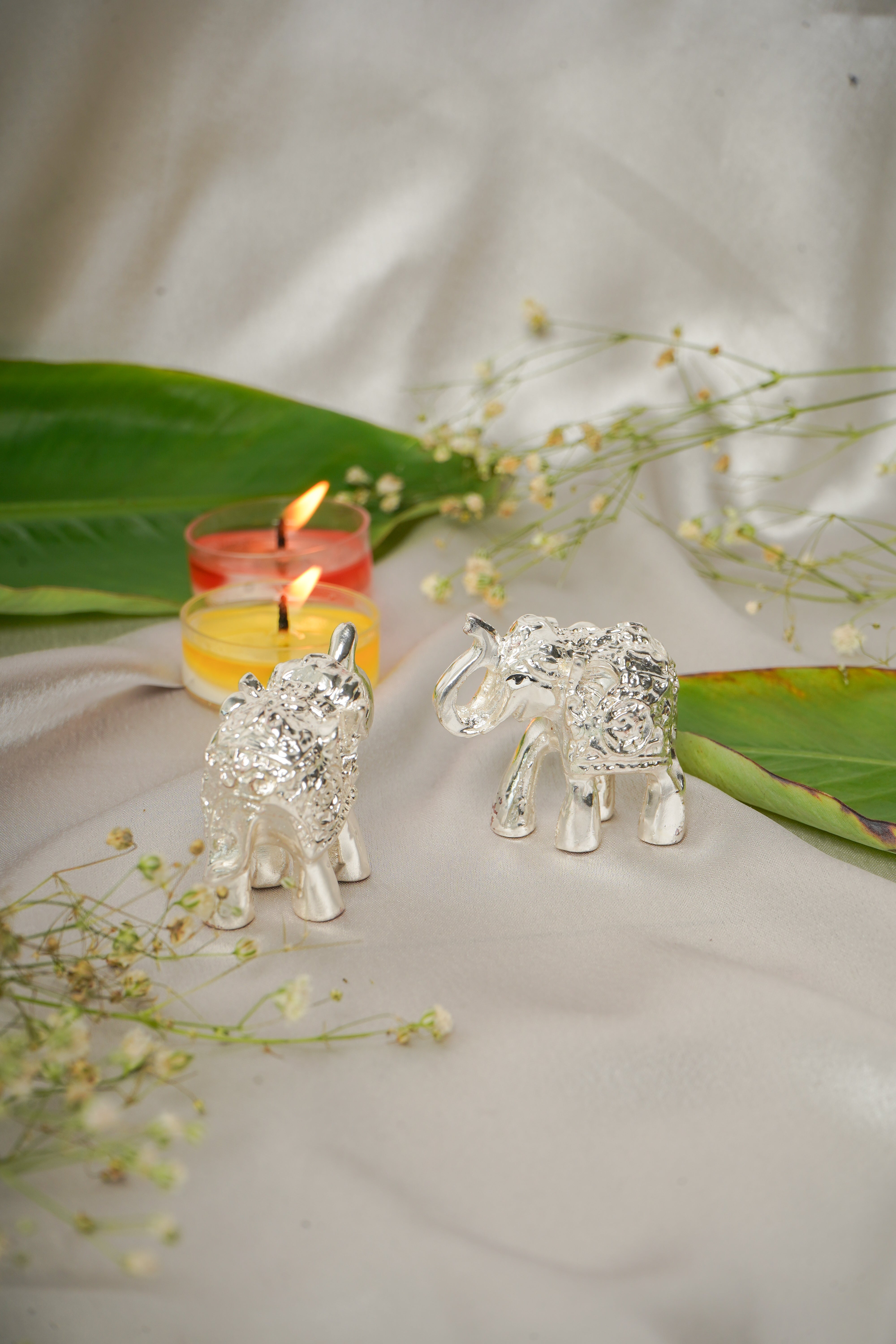 Silver plated elephant pair figurines with intricate detailing, ideal for home decor or collectibles.