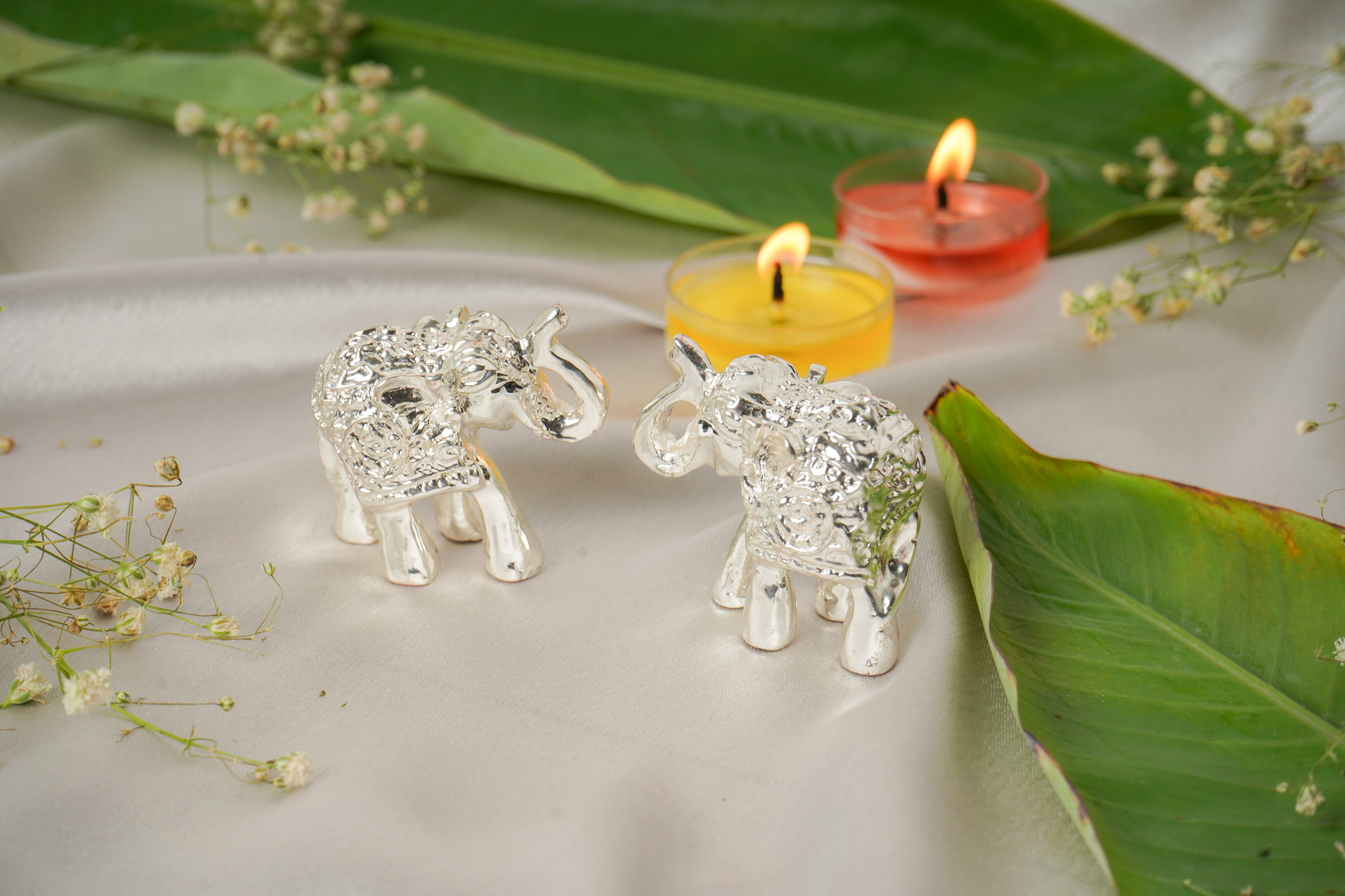 Silver plated elephant pair figurines with detailed design, ideal for home decor or collectible display.