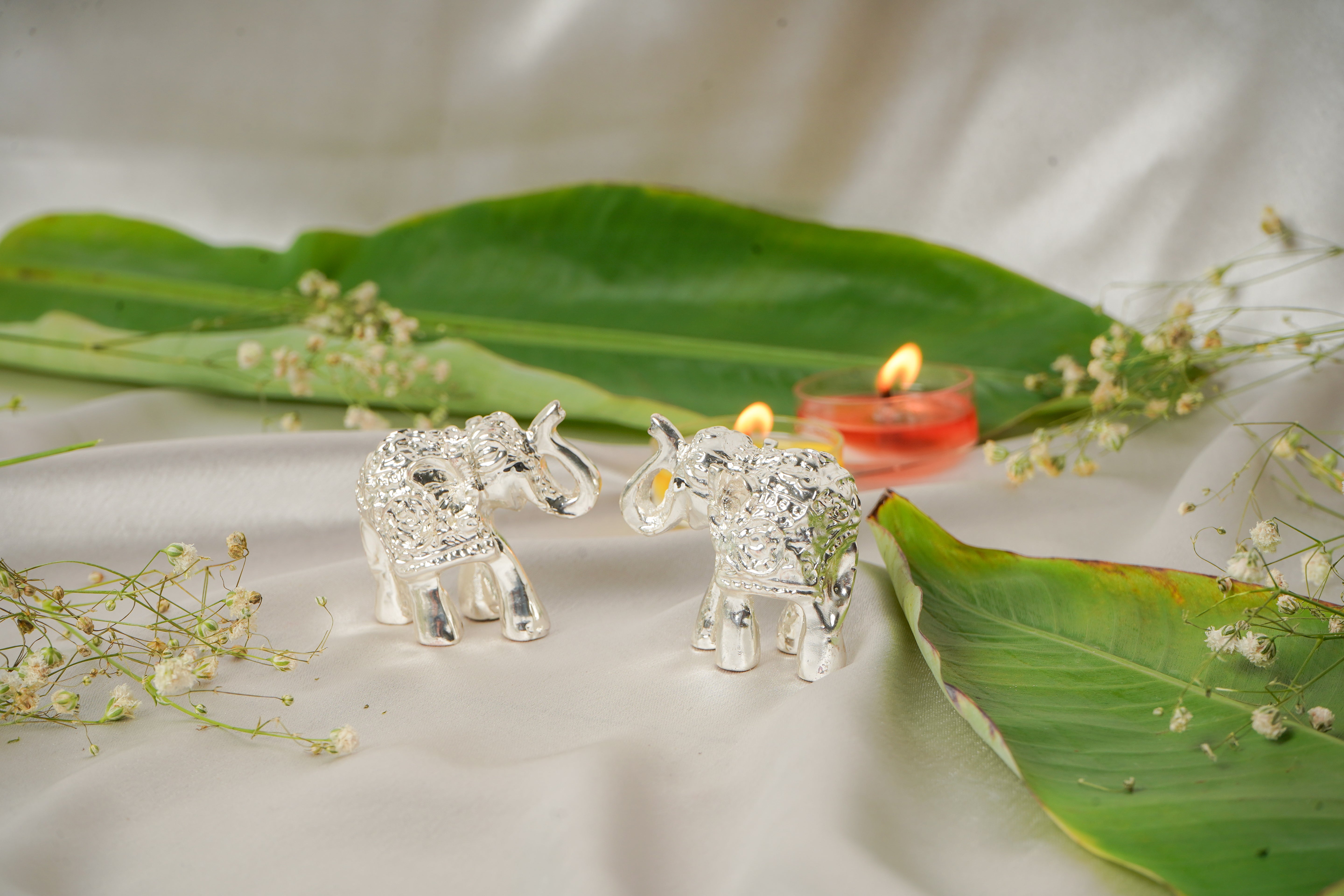 Silver plated elephant pair figurines, detailed and shiny, decorative animal sculptures for home decor.