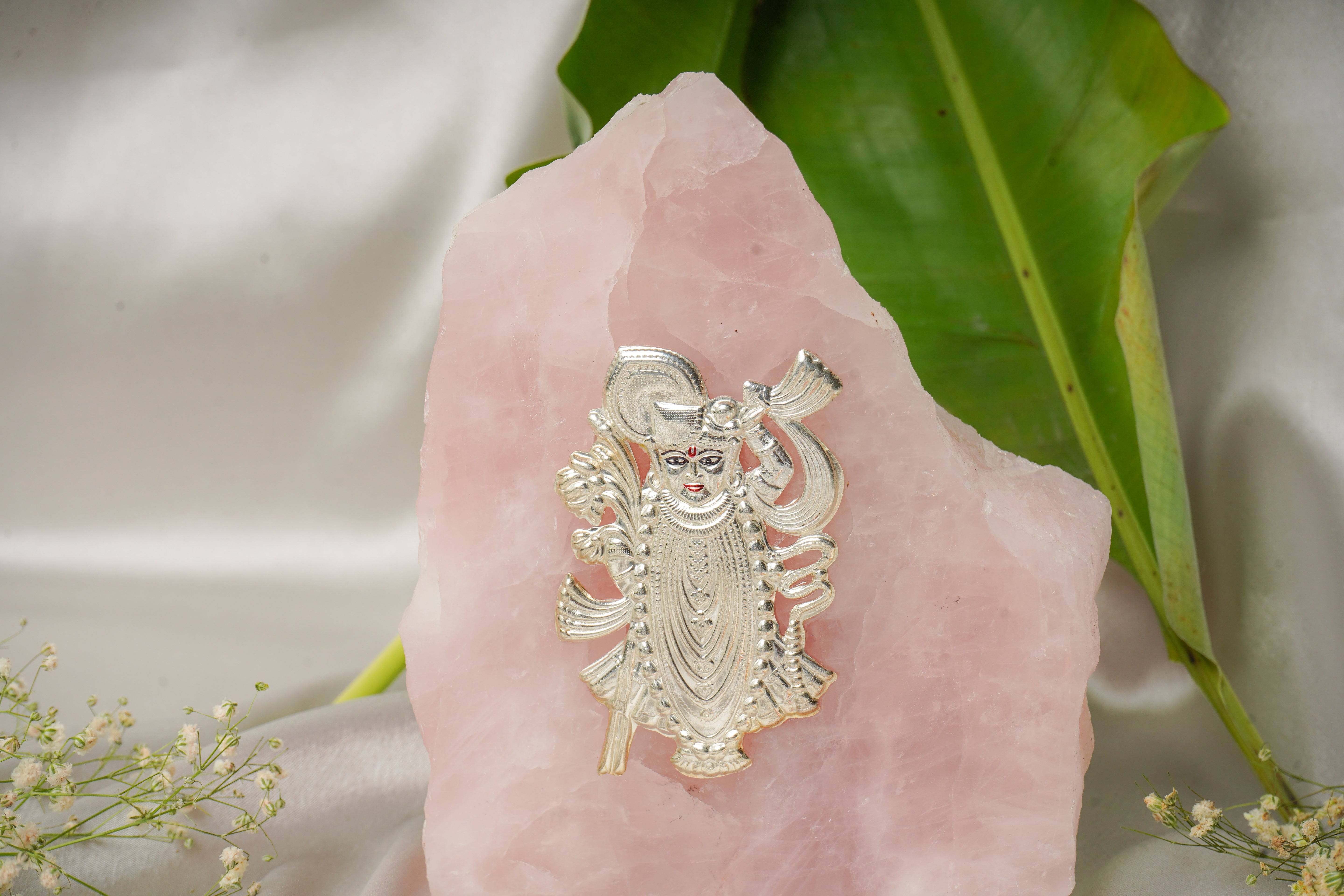 Natural rose quartz stone with pure silver Shrinath ji idol, showcasing intricate craftsmanship and vibrant pink gemstone details.
