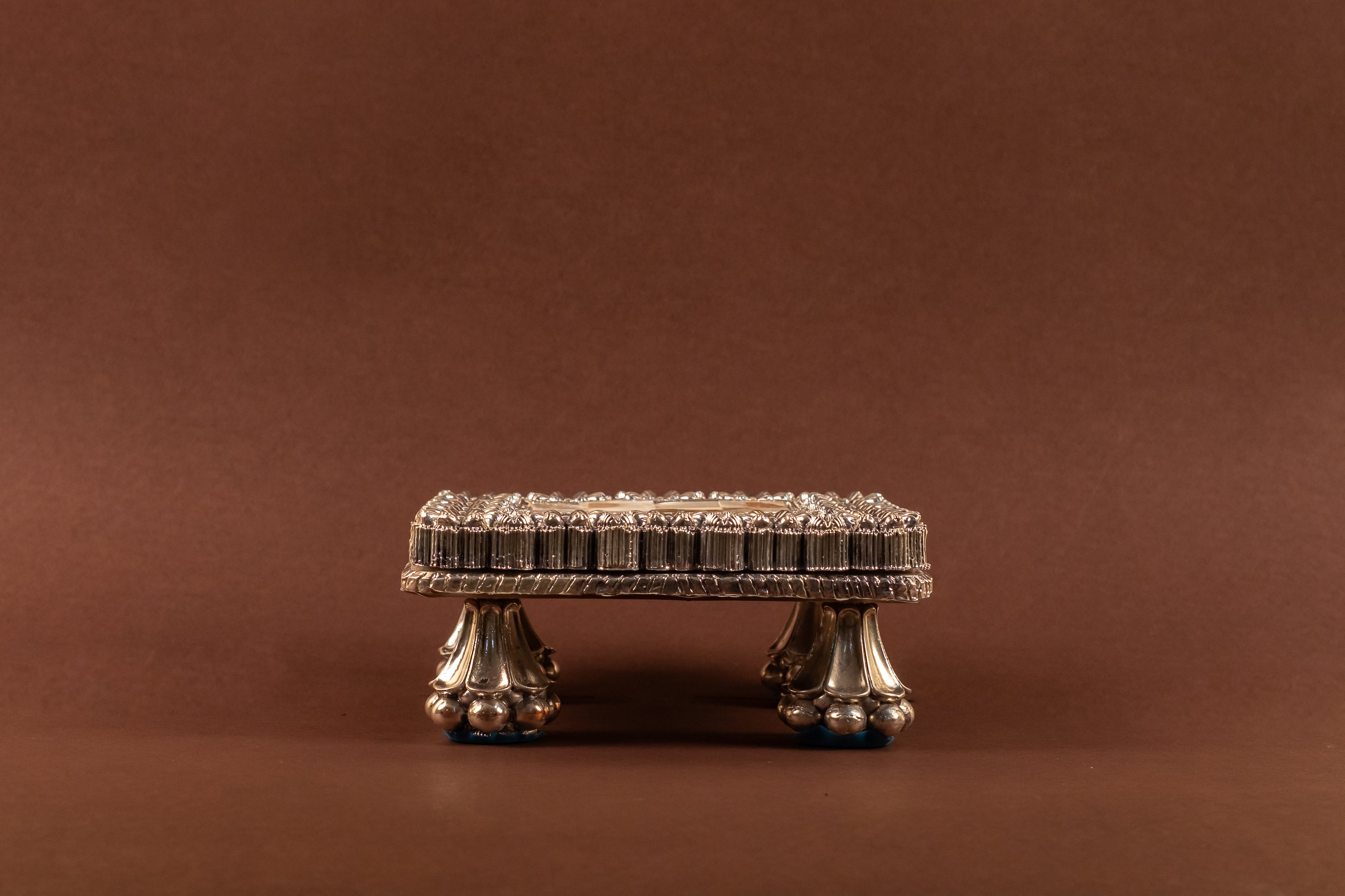 999 pure silver MOP Chowki with intricate design from Rasava Jewels, showcasing a detailed silver and mother of pearl ornament.